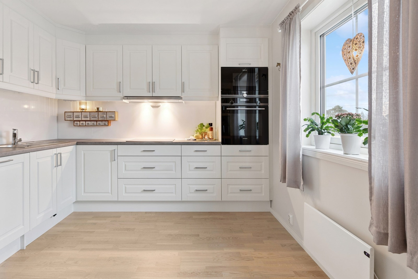 Kjøkkenet har en innholdsrik innredning med profilerte fronter og integrert stekeovn, mikroovn og oppvaskmaskin. Galleribilde