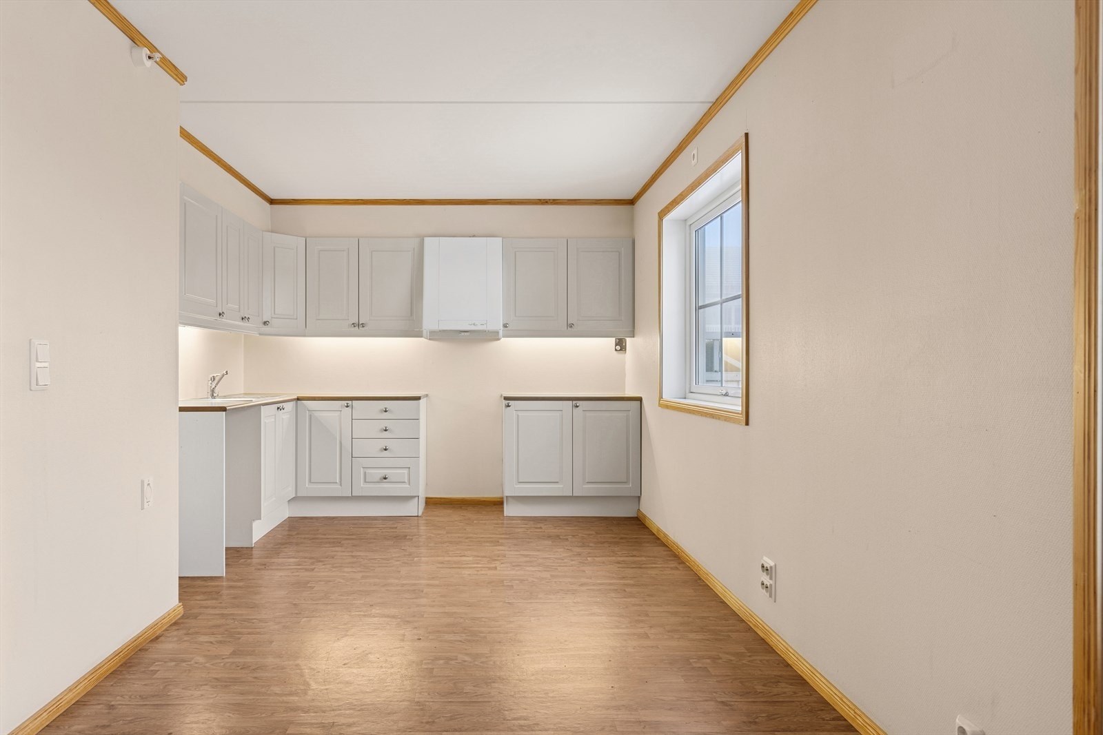 Plass for komfyr, kjøleskap og oppvaskmaskin. Kjøkkent har godt med skap og benkeplass. Galleribilde