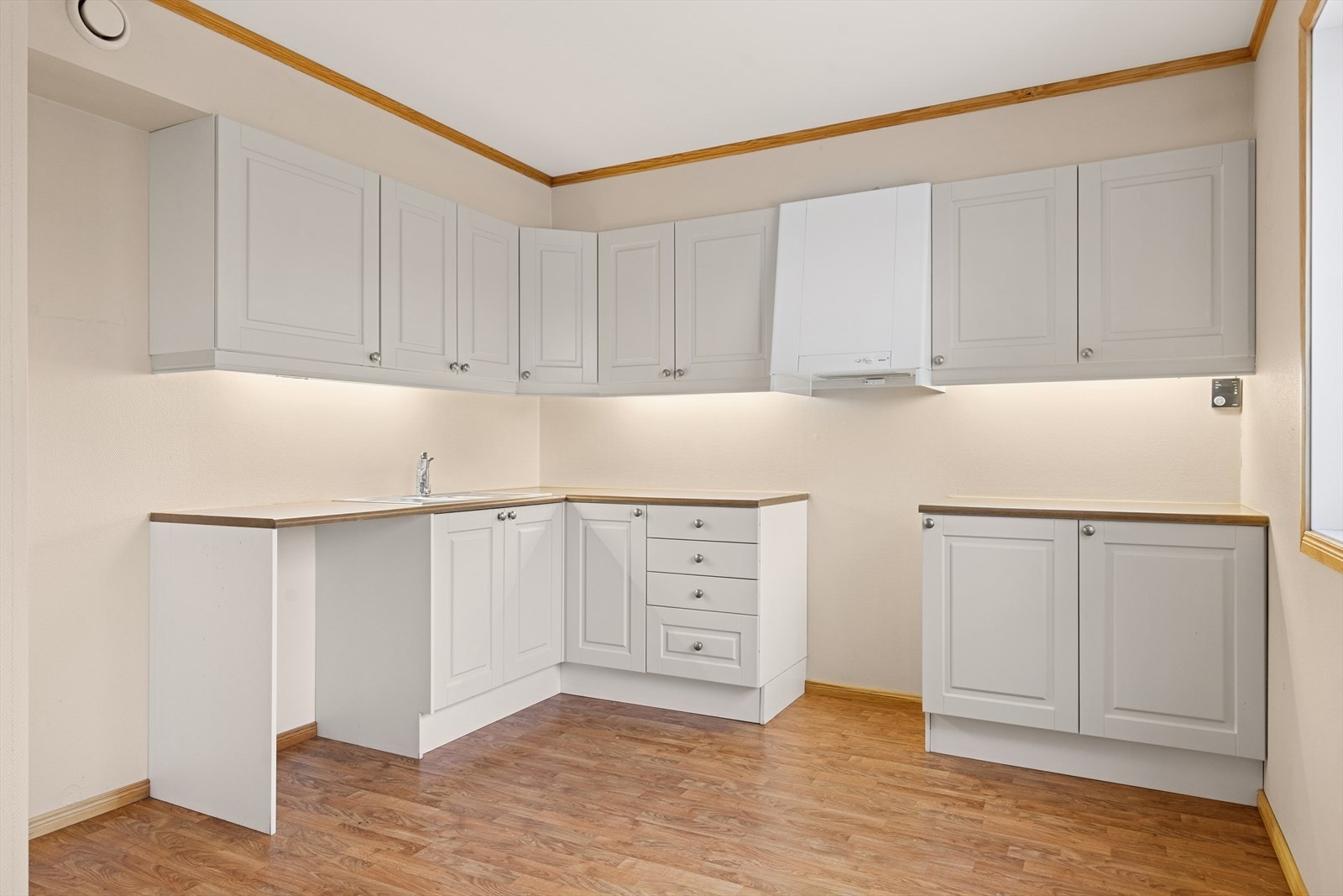 Kjøkkeninnredning med malte og profilerte fronter og laminat benkeplate med oppvaskkum. Galleribilde