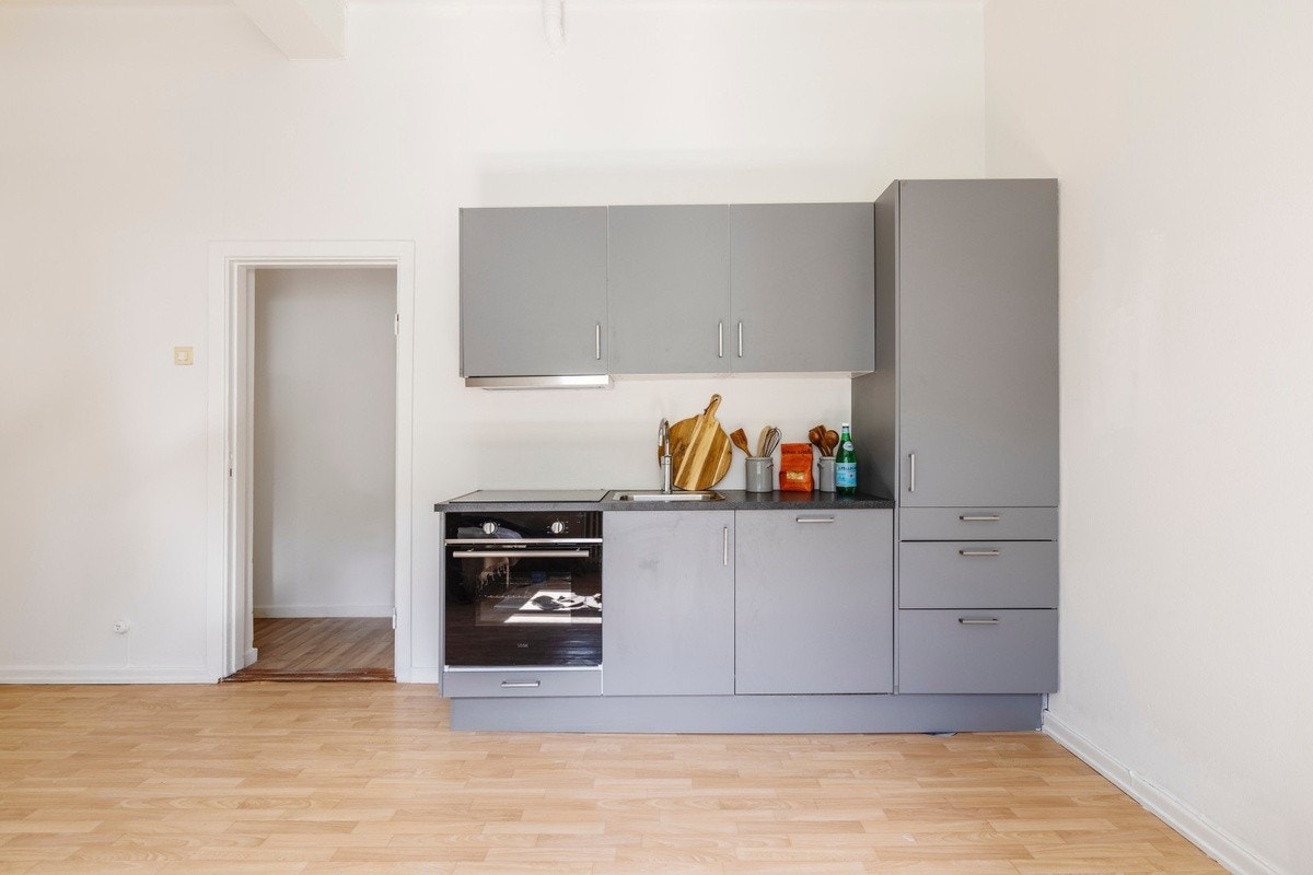 Flott oppusset 1-roms leilighet med gode lysforhold og et moderne kjøkken fra HTH som inneholder kjøleskap med fryseboks, komfyr, koketopp med induksjon og oppvaskmaskin. Galleribilde