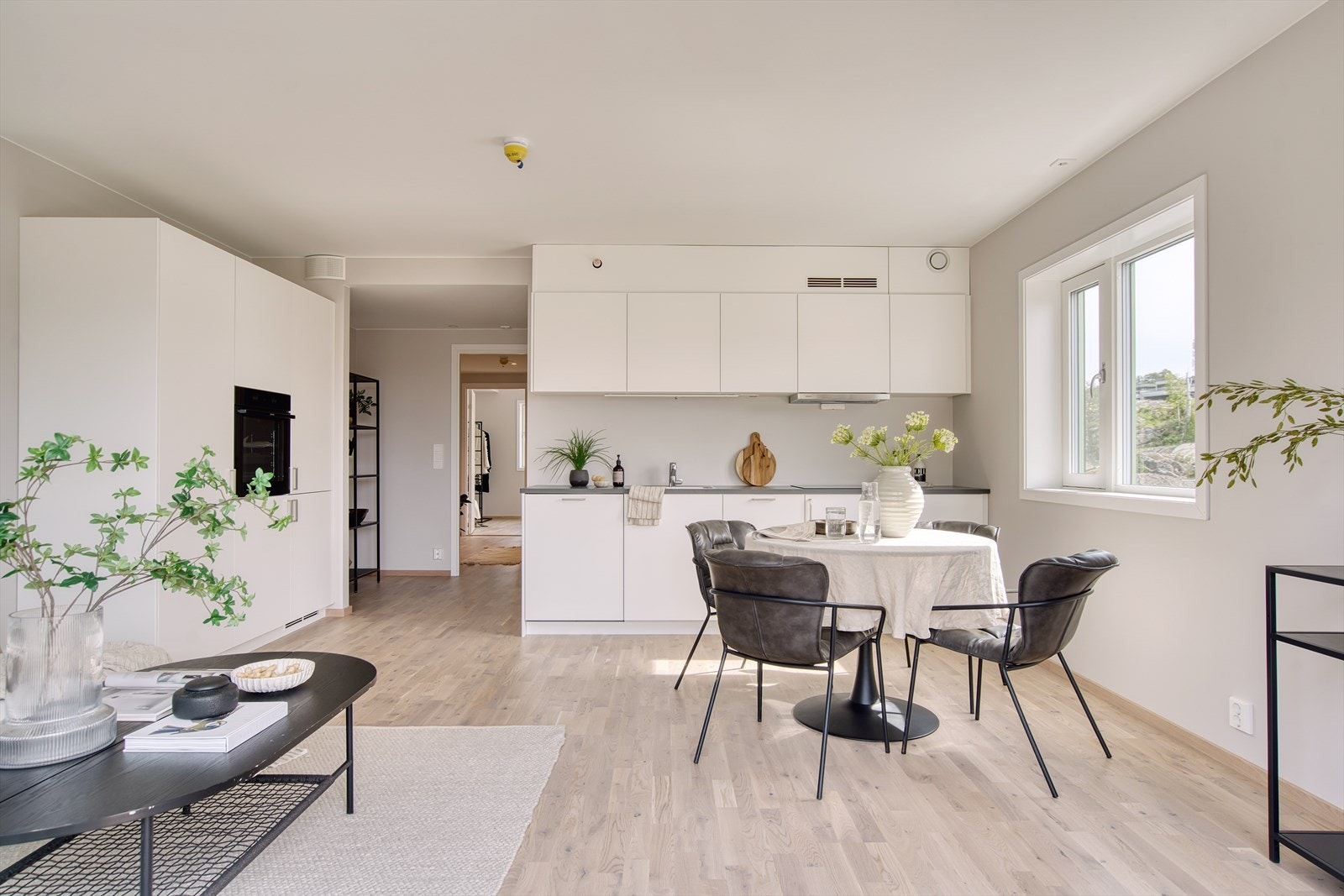 Kjøkkenet har slett, hvit innredning i over-, under- og høyskap med integrerte hvitevarer. Galleribilde