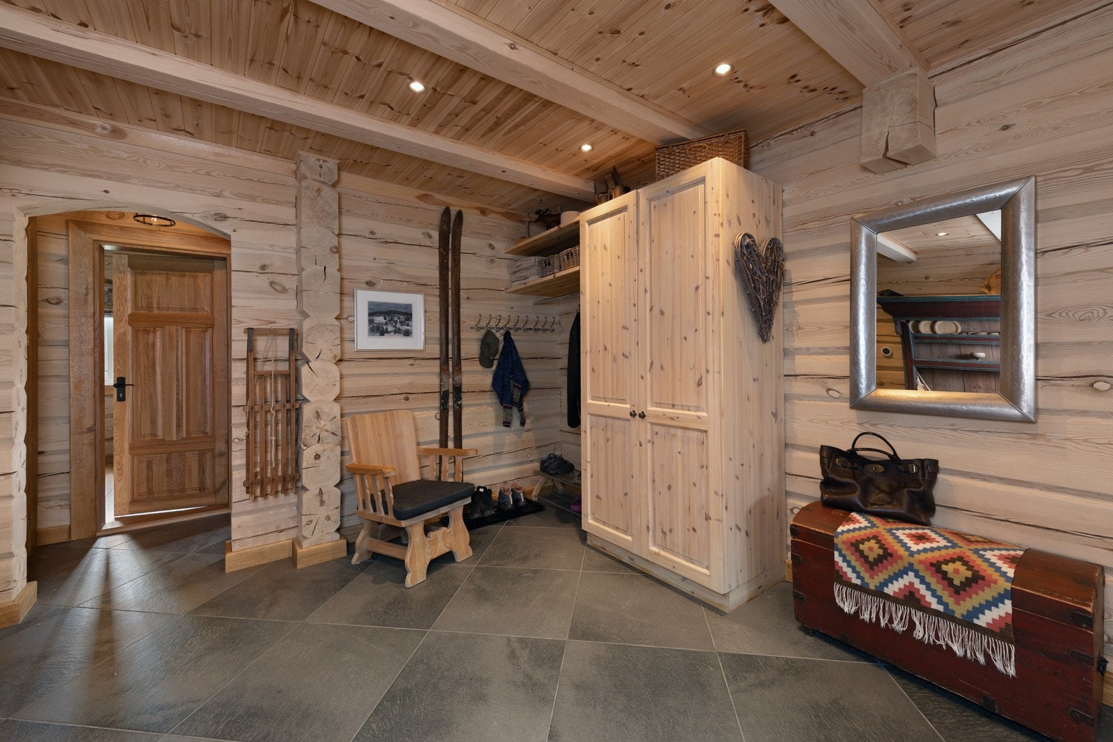 Romslig gang med flislagt gulv, garderobeskap og sitteplass. Galleribilde