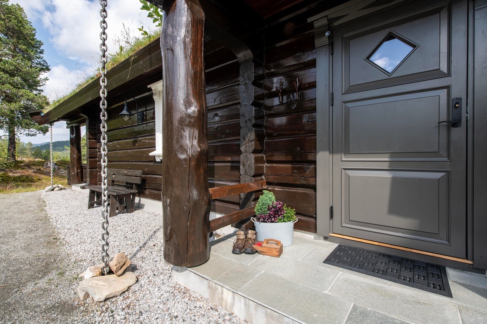 Overbygd inngangsparti med grå dør. Galleribilde