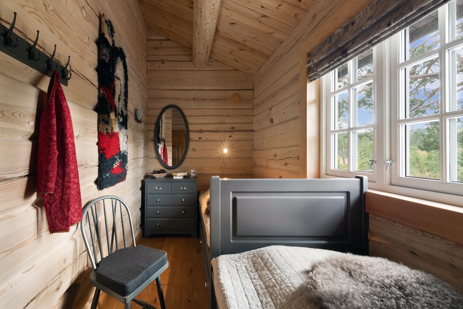 Rommet har tømmervegger, skråtak og vindu med utsikt Galleribilde