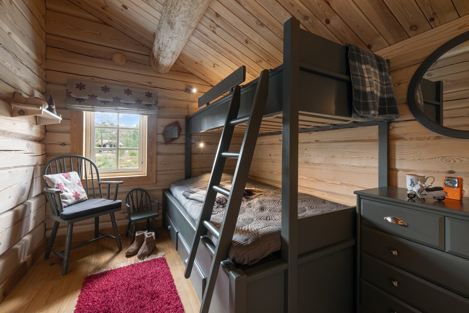 Rommet har køyeseng og kommode. Vegger og tak er i tre med synlige bjelker. Galleribilde