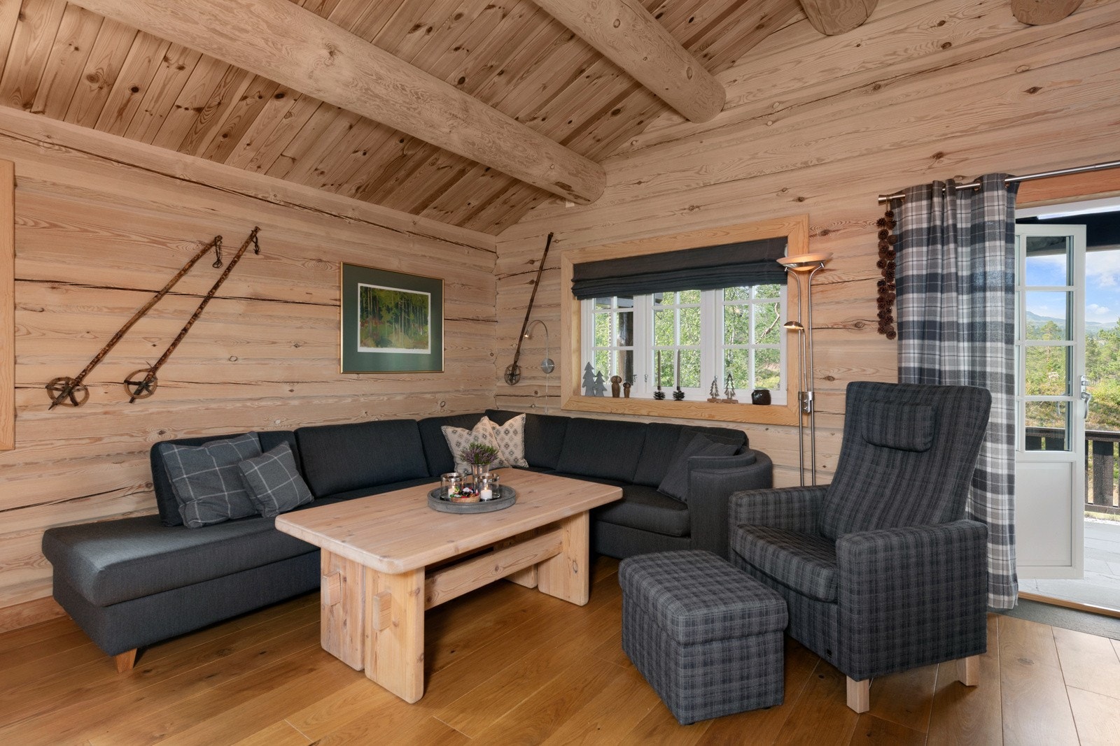 Stue med tømmervegger, skråtak og vindu som gir naturlig lysinnslipp. Galleribilde