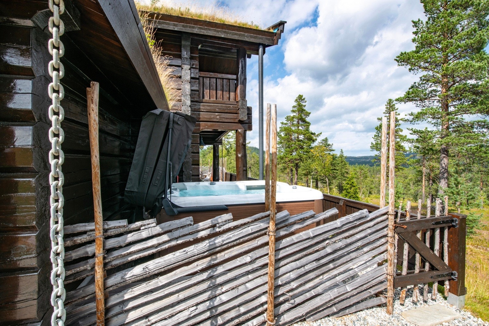Utendørs boblebad med utsikt over skog og fjell. Galleribilde