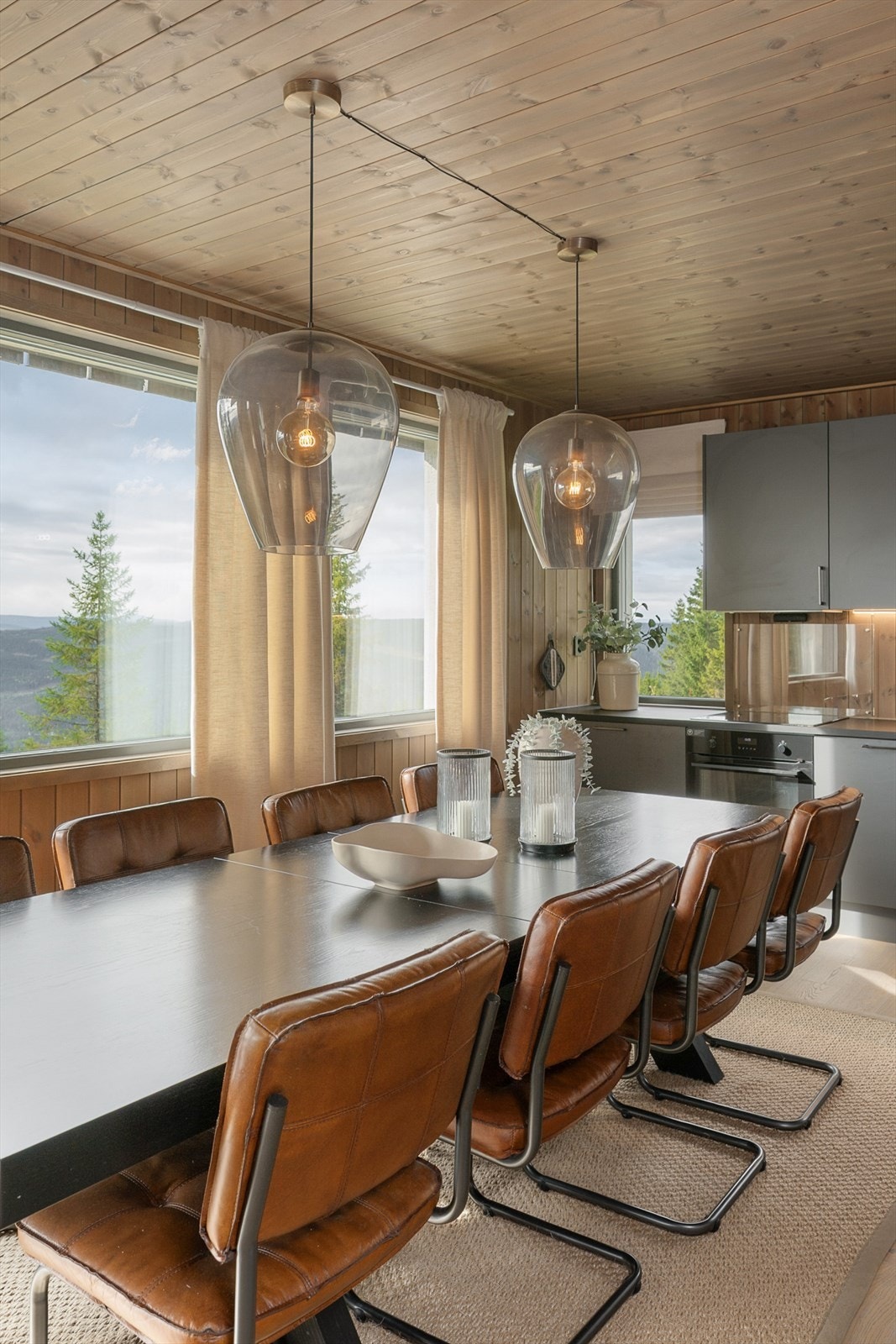 Den åpne løsningen gir god flyt mellom kjøkken og stue, og store vinduer slipper inn rikelig med lys. Galleribilde