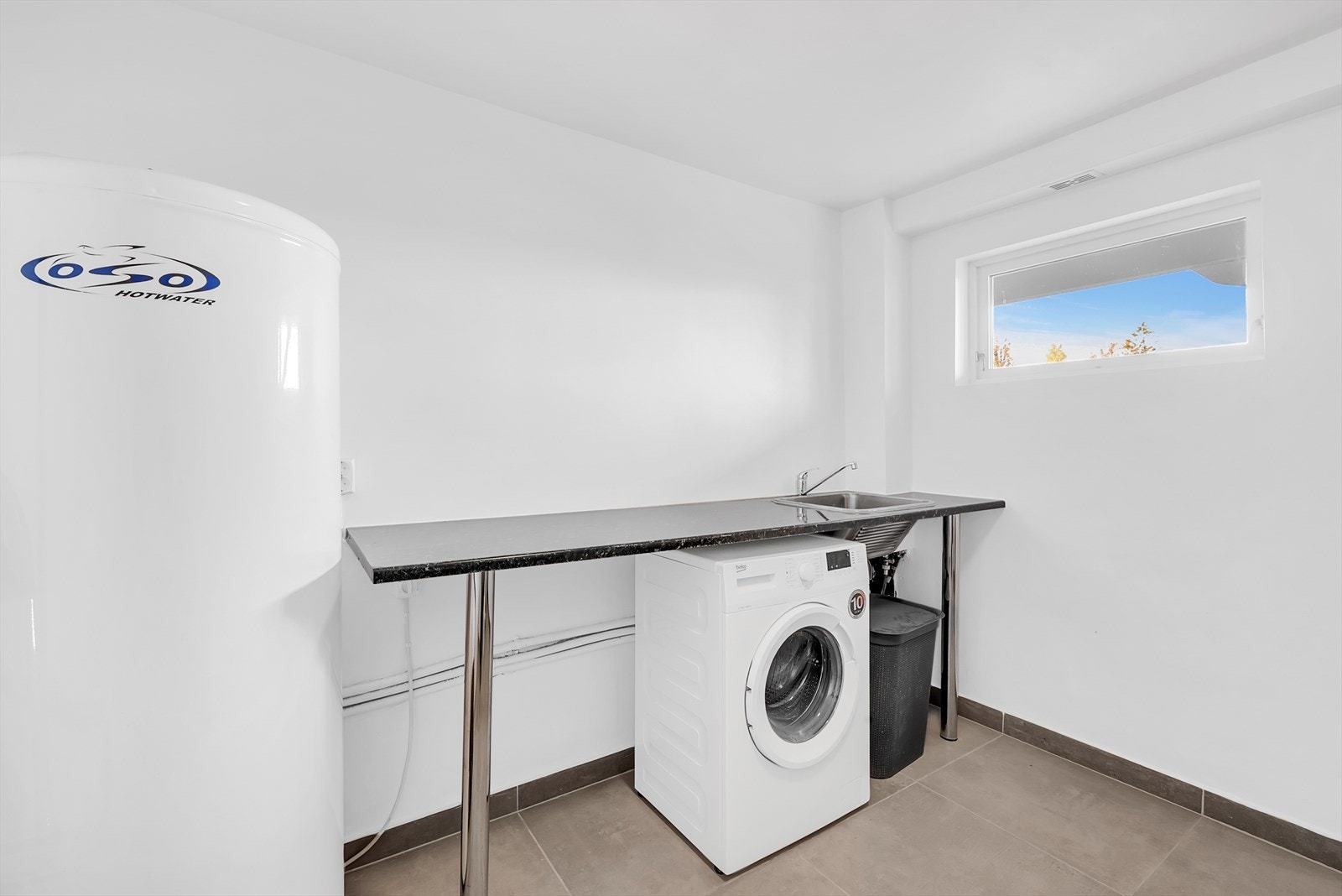 Vaskerom fra 2024 med laminat benkeplate og utslagskum i rustfritt stål. Det er opplegg for vaskemaskin. (Medfølger ikke ved handelen). Galleribilde