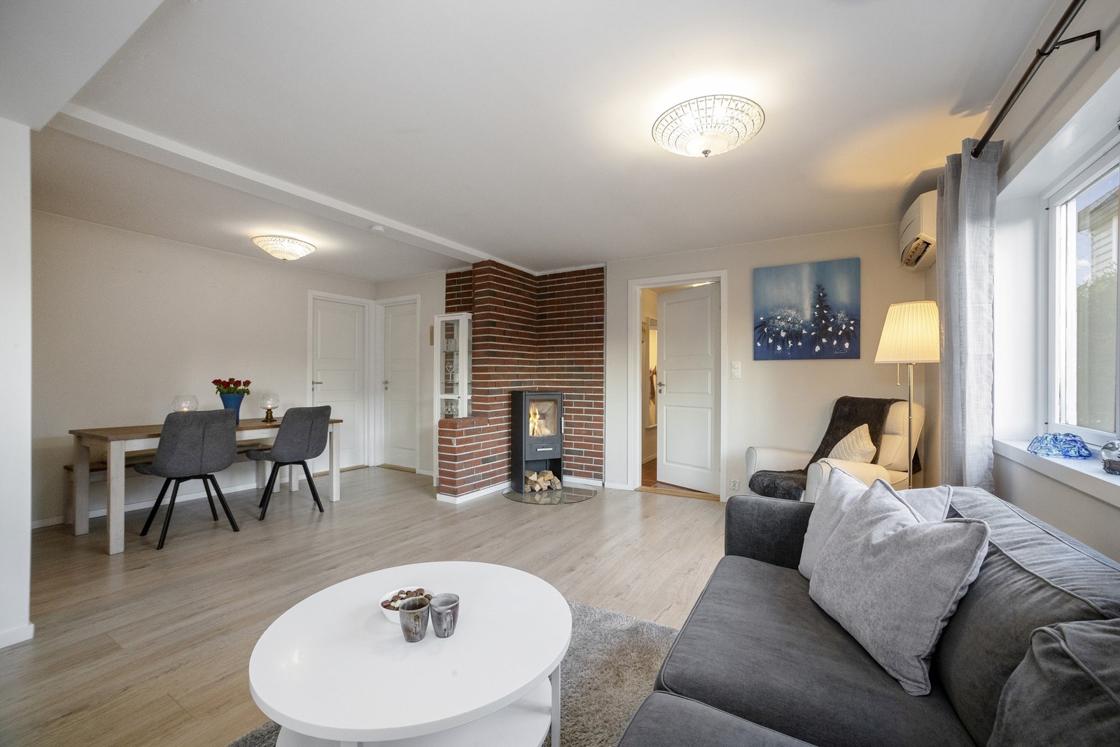 Stuen fremstår innbydende med laminatgulv og malte overflater i lyse farger Galleribilde