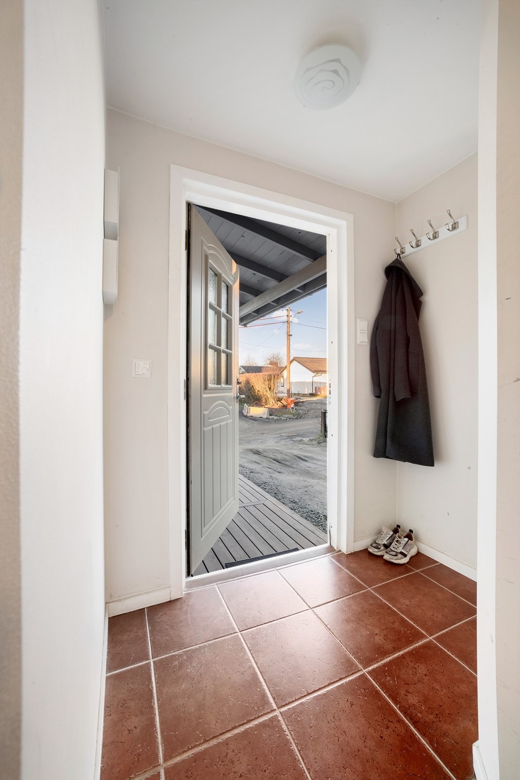 Man kommer inn i en flislagt entré med gulvvarme Galleribilde