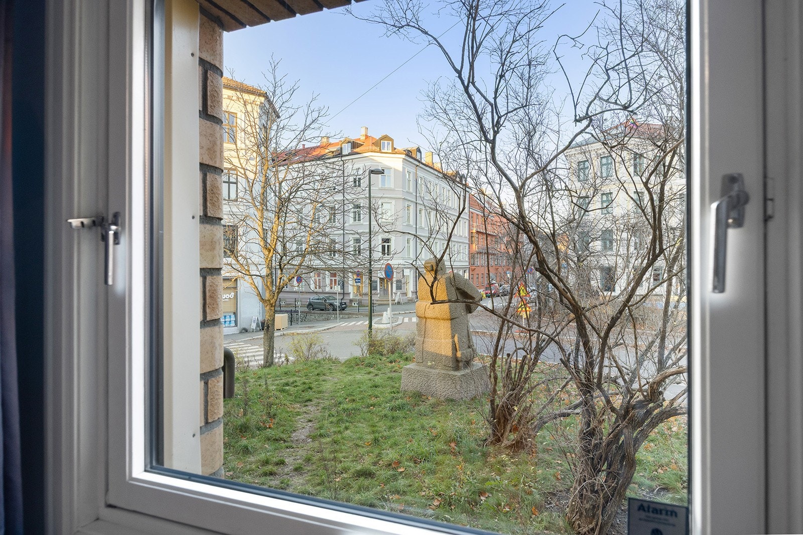 Utsikten mot Sørlis plass med fontenen er lys om vinteren og grønn og frodig om sommeren Galleribilde