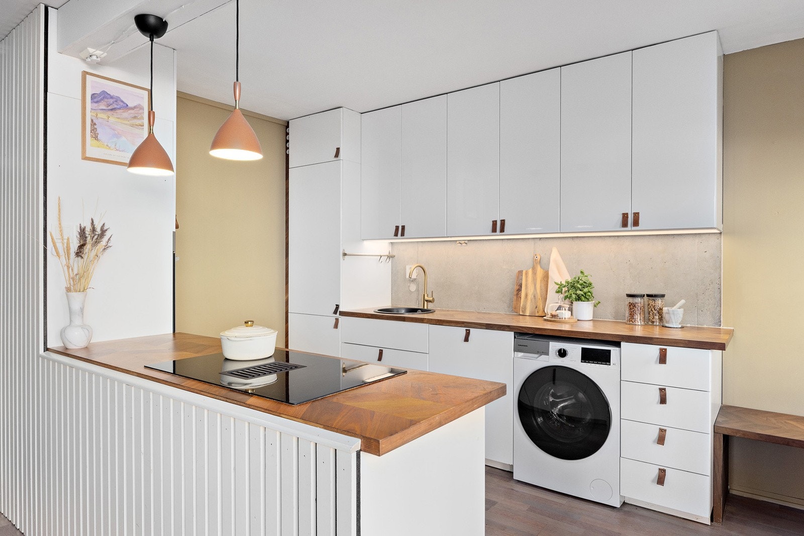 Deler av kjøkkenvegg i råbetong. Vaskemaskin og integrert oppvaskmaskin Galleribilde