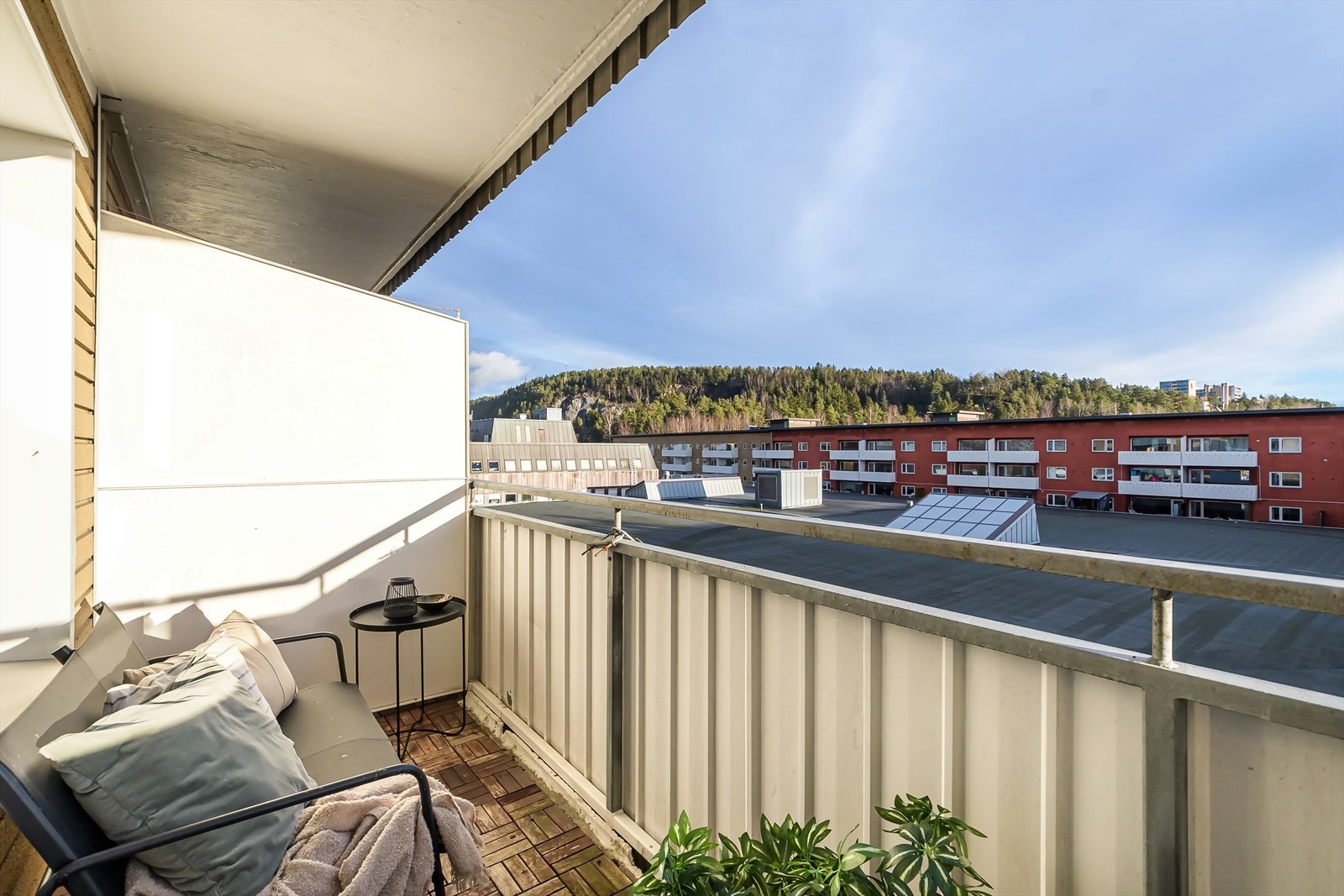 Overbygget balkong med trefliser på gulvet. God plass til utemøblement. Galleribilde