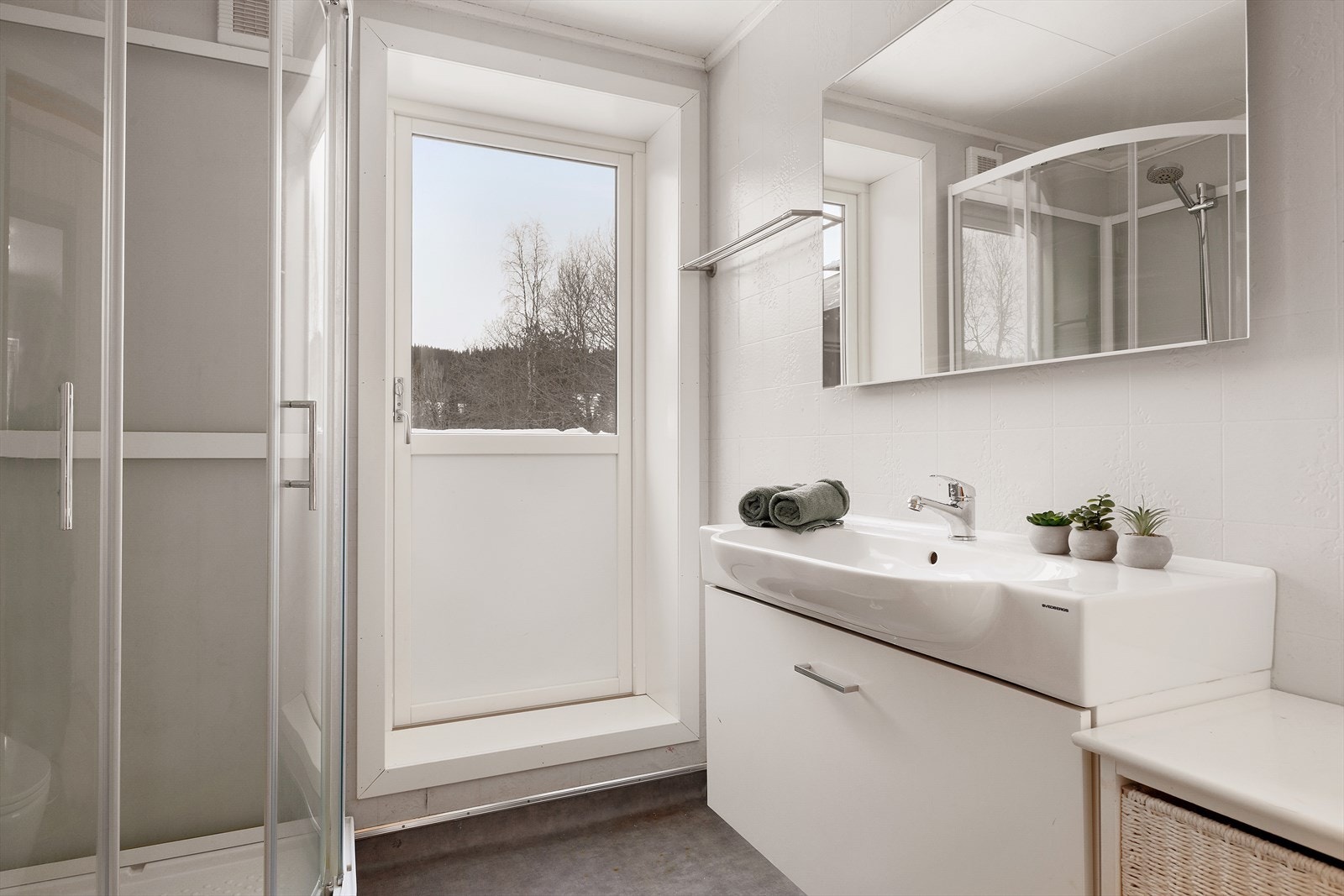 Badet ligger i andre etasje og har baderomsinnredning med heldekkende servant, dusjkabinett og toalett. Galleribilde