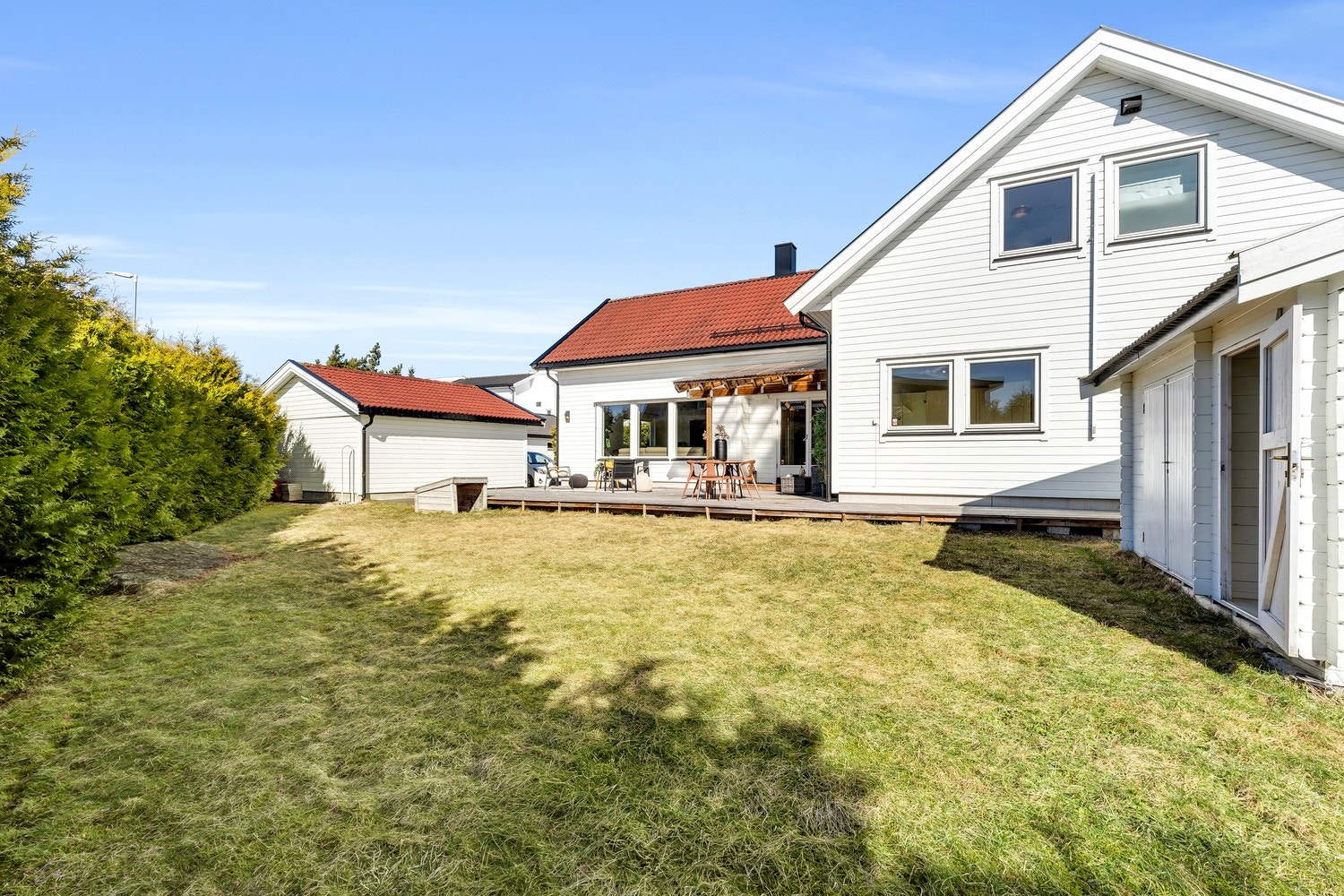 Eiendommen er også pent opparbeidet med gressplen og beplantning. Deler av tomten er innrammet med hekk som skjermer mot innsyn fra naboer og forbipasserende. Perfekt for familielivet. Galleribilde