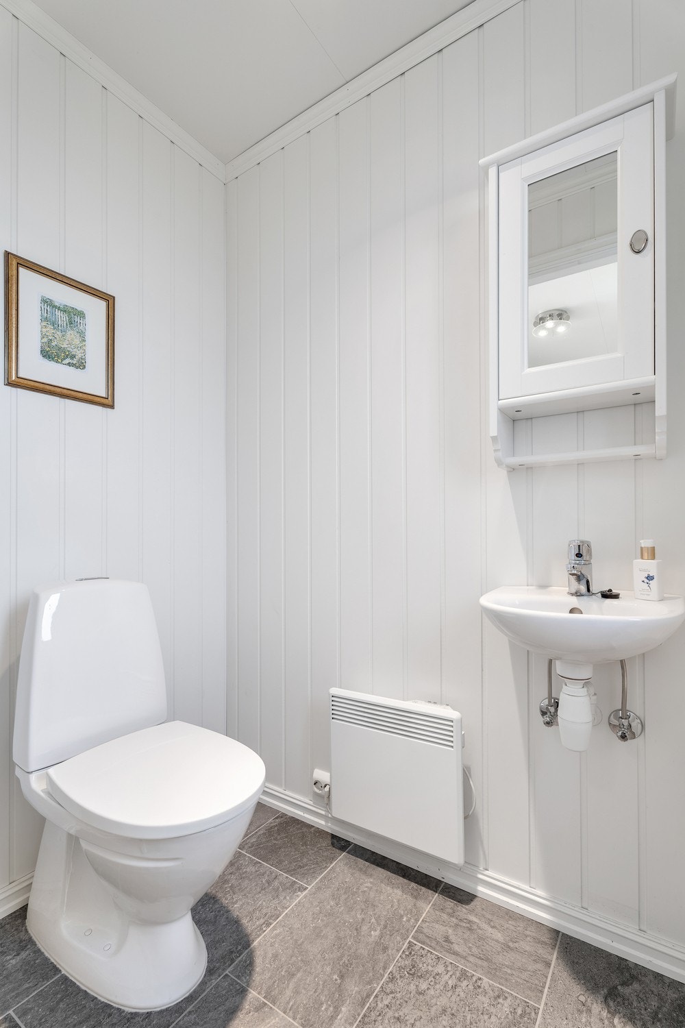 Praktisk gjesteoalett! Toalettrommet har flislagt gulv, MDF smartpanel på vegger og takessplater på innvendig tak. Gulvmontert toalett og vegghengt servant. Galleribilde