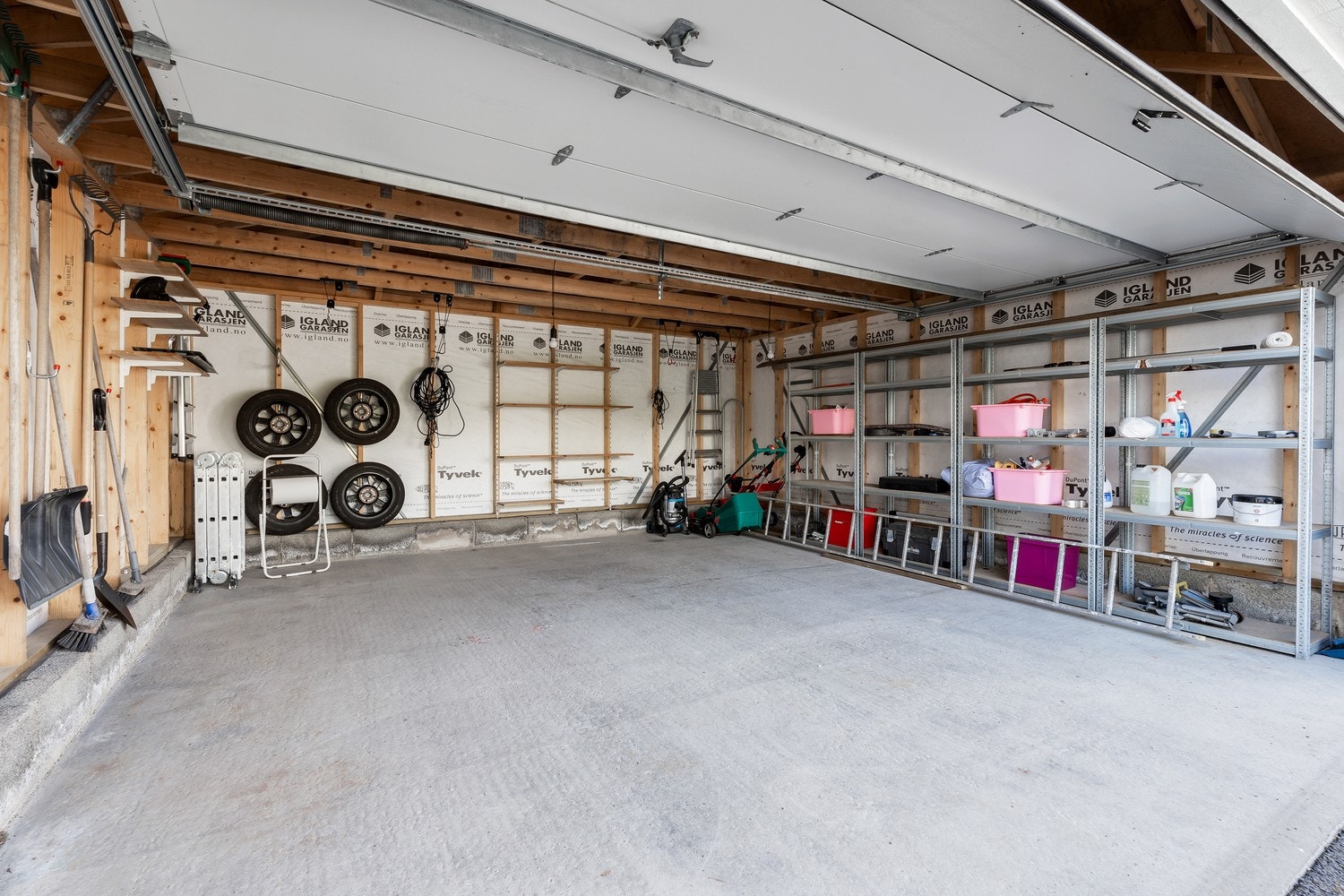 Boligen har en praktisk dobbeltgarasje med manuell leddport. Det er god plass til parkering på egen eiendom, både i garasjen og utenfor. Galleribilde