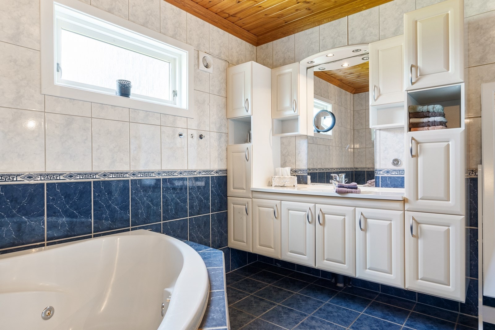 Det store badet er perfekt for avslapning og velvære i hverdagen. Flislagt, varmekabler, hjørnebadekar, servant og mye skapplass. Galleribilde