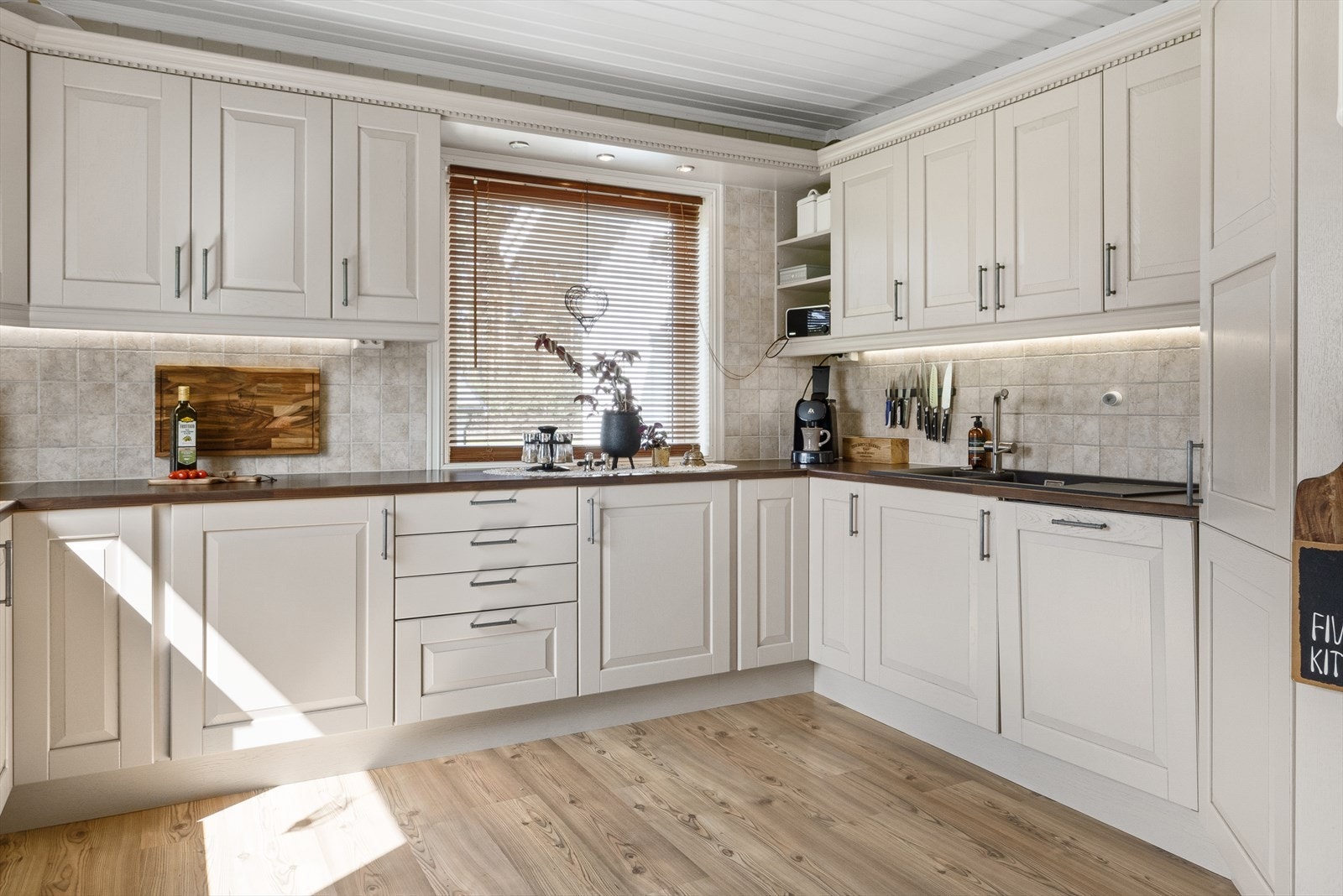 Meget innholdsrikt kjøkken med mye benke- og skapplass. Galleribilde