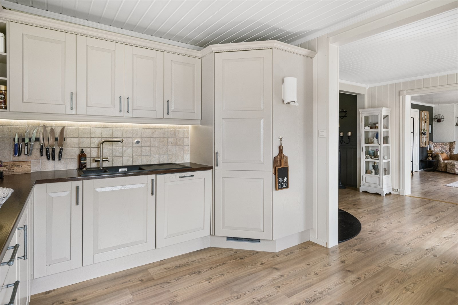 Lyst og romslig kjøkken med moderne løsninger og praktisk utforming. Kjølehjørne og integrerte hvitevarer. Galleribilde