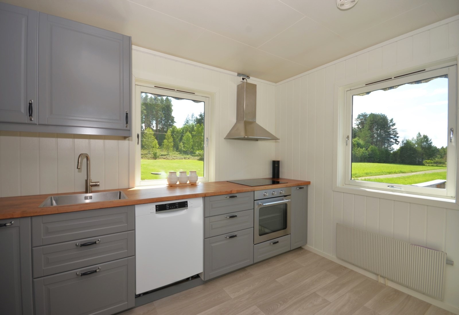 Lyst og moderne kjøkken med mye skapplass og naturskjønn utsikt. Plass til spisebord. Galleribilde