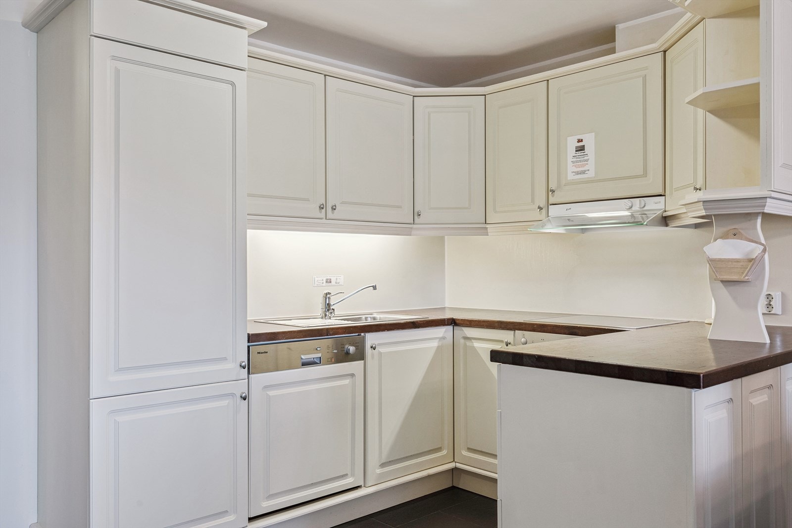 Kjøkkenet er innredet med malt heltre innredning, heltre benkeplate og oppvaskkum med kran av stål. Galleribilde