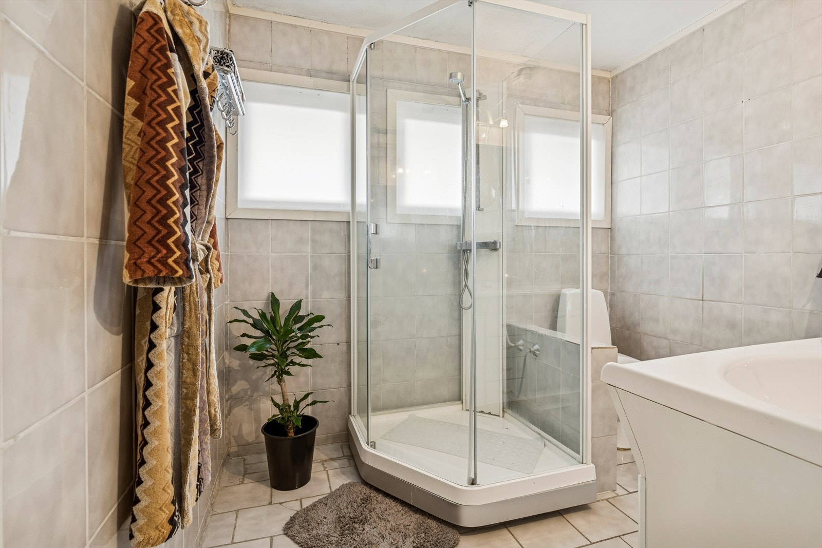 Badet i hoveddelen er flislagt og utstyrt med dobbeltservant, dusjkabinett og gulvvarme. Galleribilde