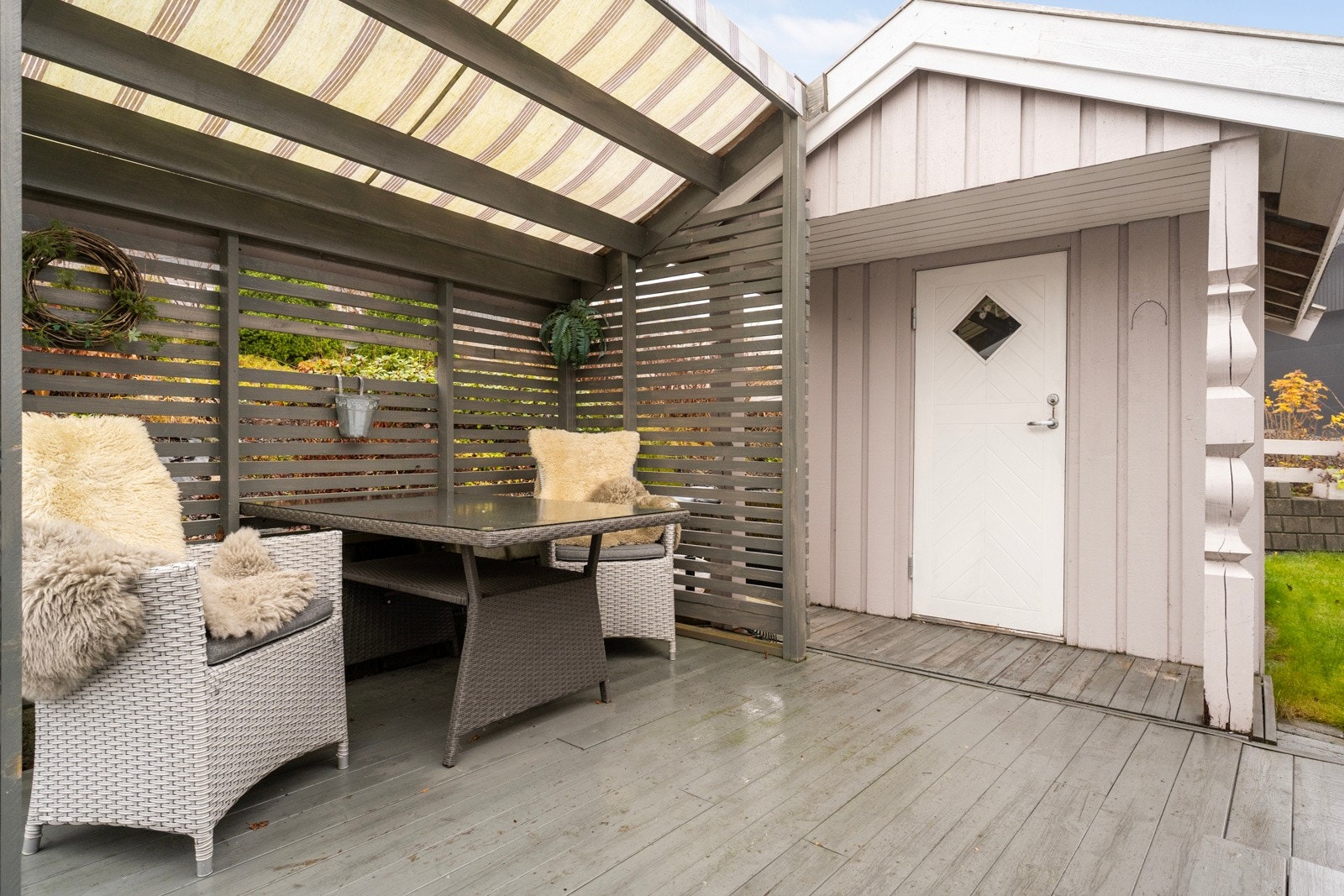 Fin solrik og delvis overbygd uteplass ved inngangsparti der er det også en hagebod Galleribilde