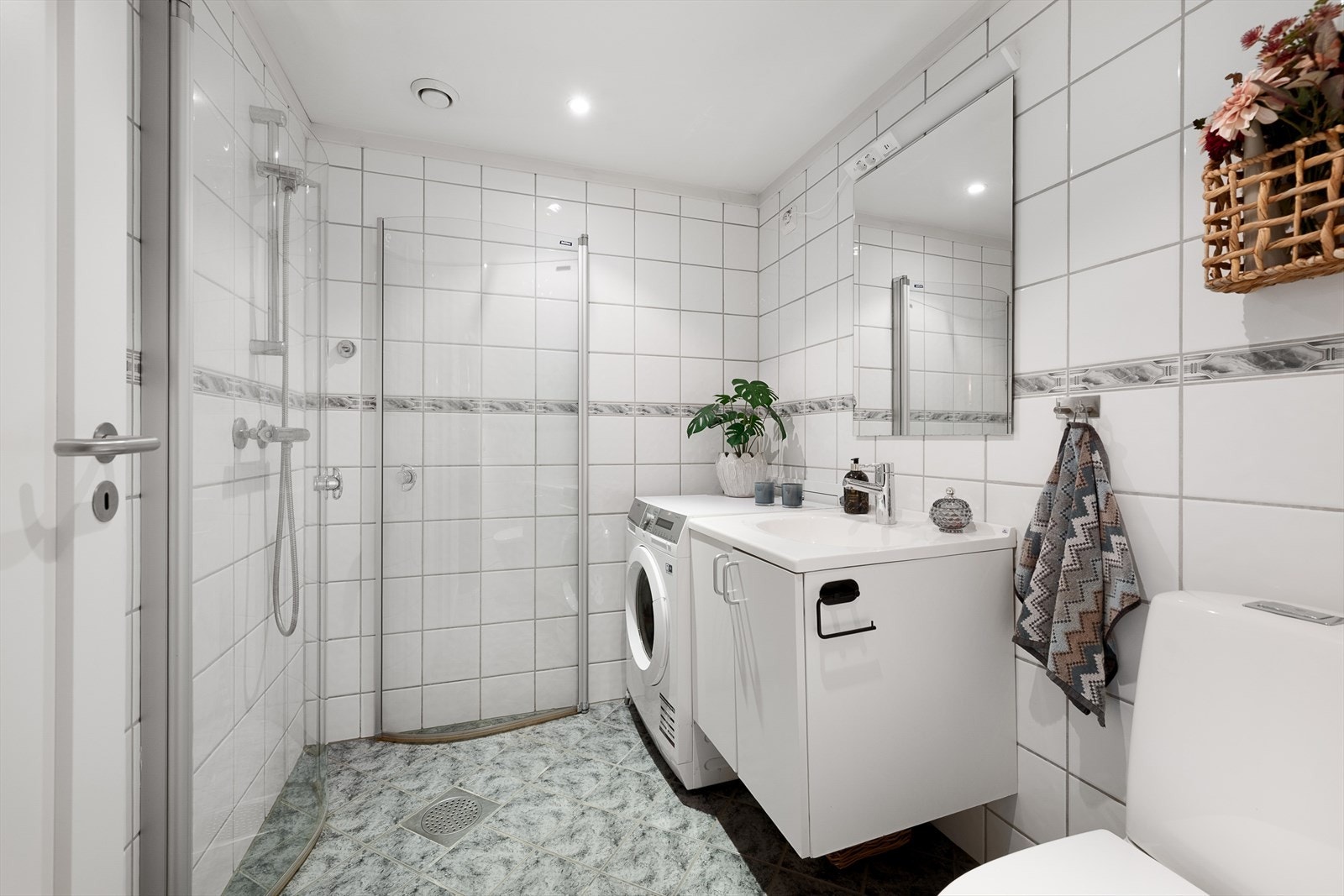 Flislagt bad med varmekabler i gulvet og dusjhjørne med dører i herdet glass. Galleribilde