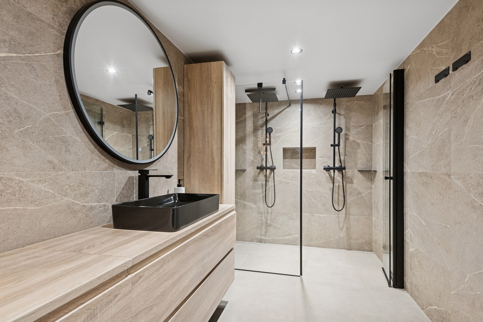 Badet har en romslig dusjsone med to separate dusjhoder og innfelte hyller. Galleribilde