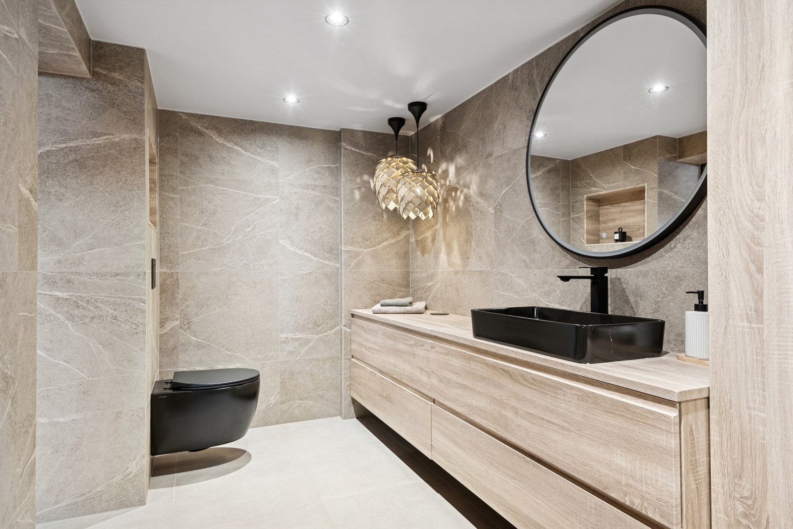 Hovedbadet i kjelleren ble pusset opp i 2025 med store fliser og moderne innredning. Galleribilde