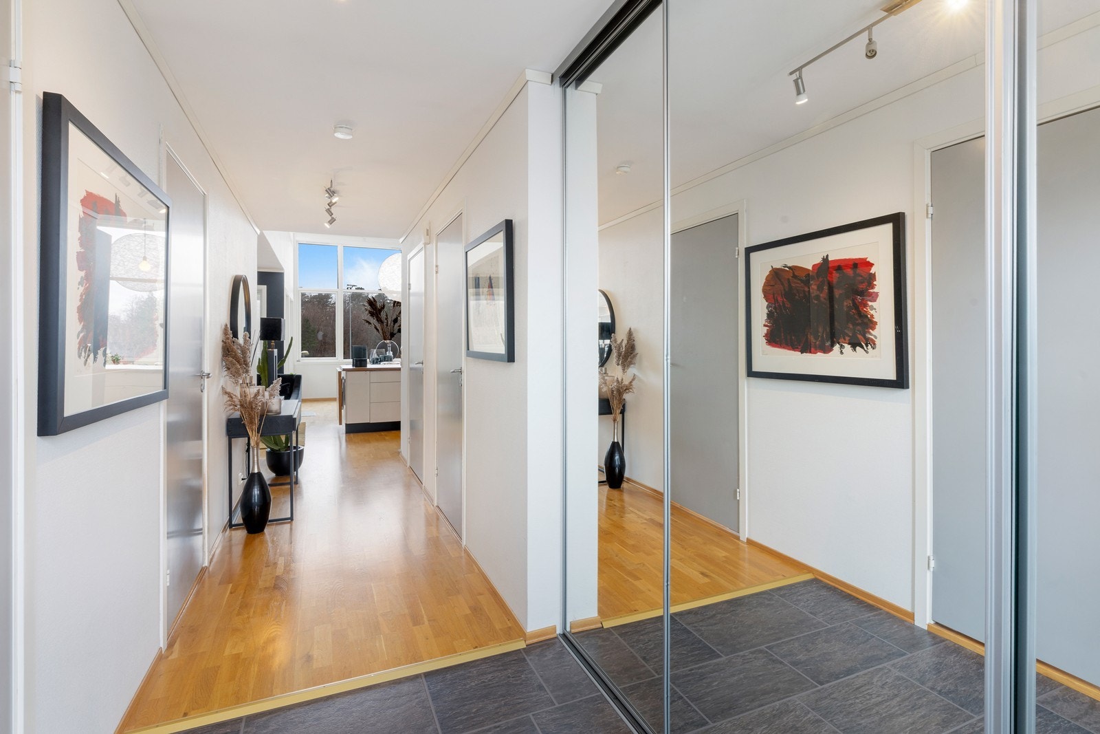 I leiligheten er det en romslig gang med god plass til å henge fra seg yttertøy og sko i skyvedørsgarderobe. Galleribilde
