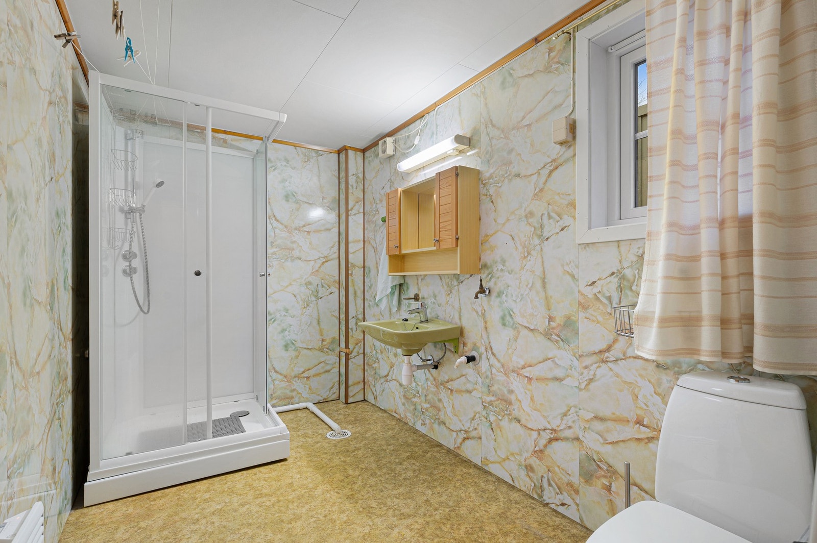 Bad fra byggeår med baderomsplater på vegg og plater i himling. Galleribilde