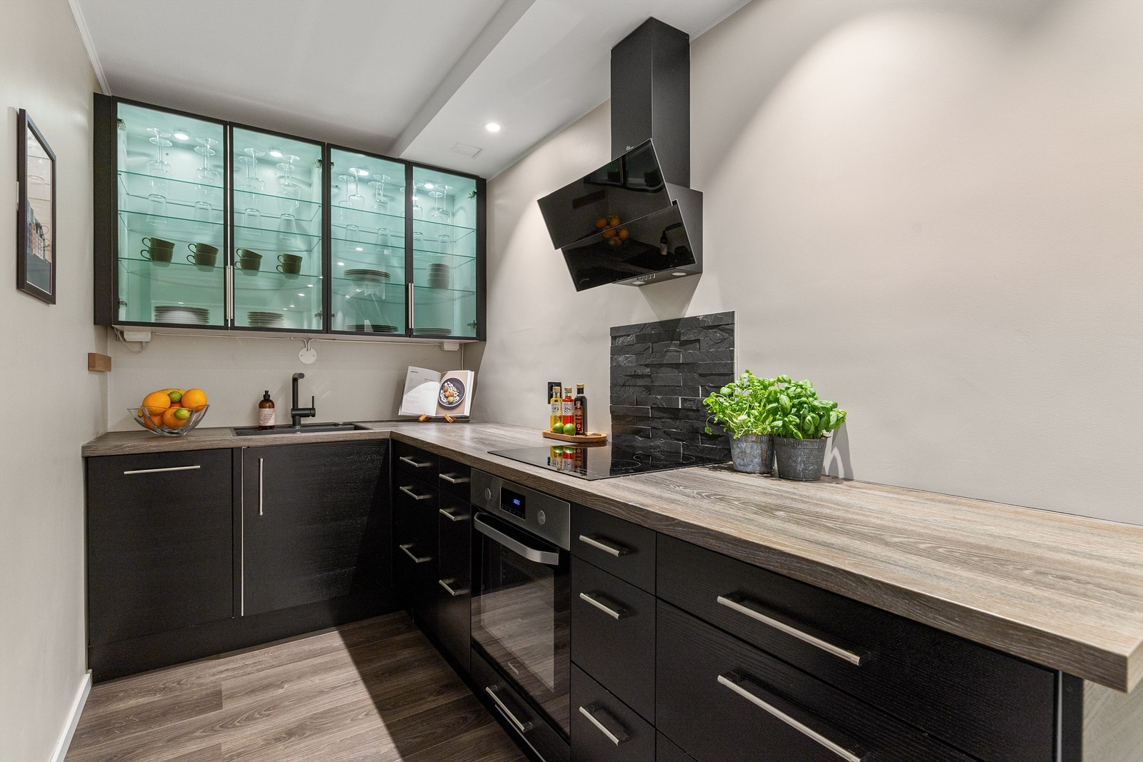 Innredning fra Epoc med sorte, glatte skapfronter, laminat benkeplate, nedfelt oppvaskkum og ett-greps armatur, begge i sort utførelse Galleribilde