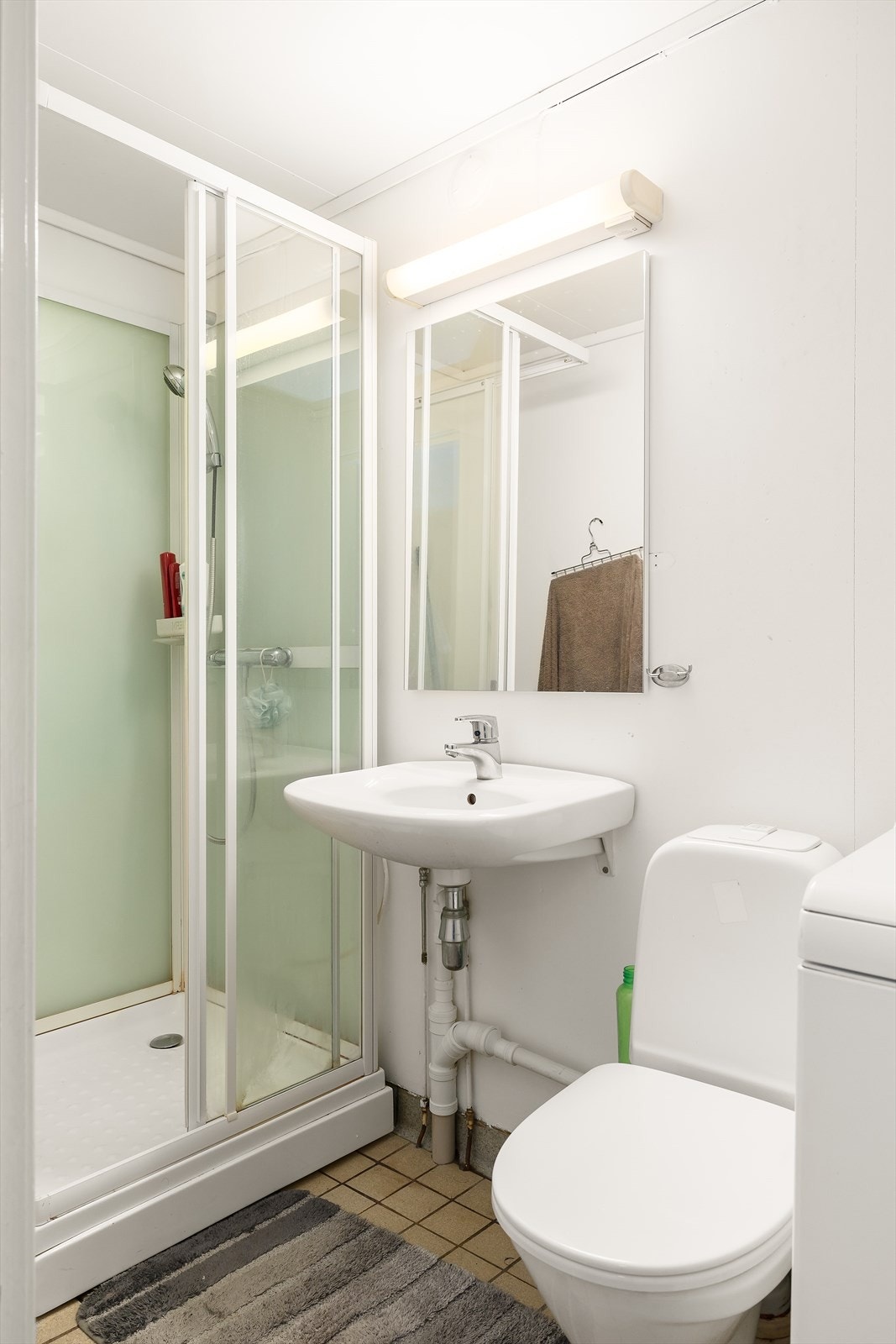 Bad i leilighet med dusjkabinett og servant med overspeil Galleribilde