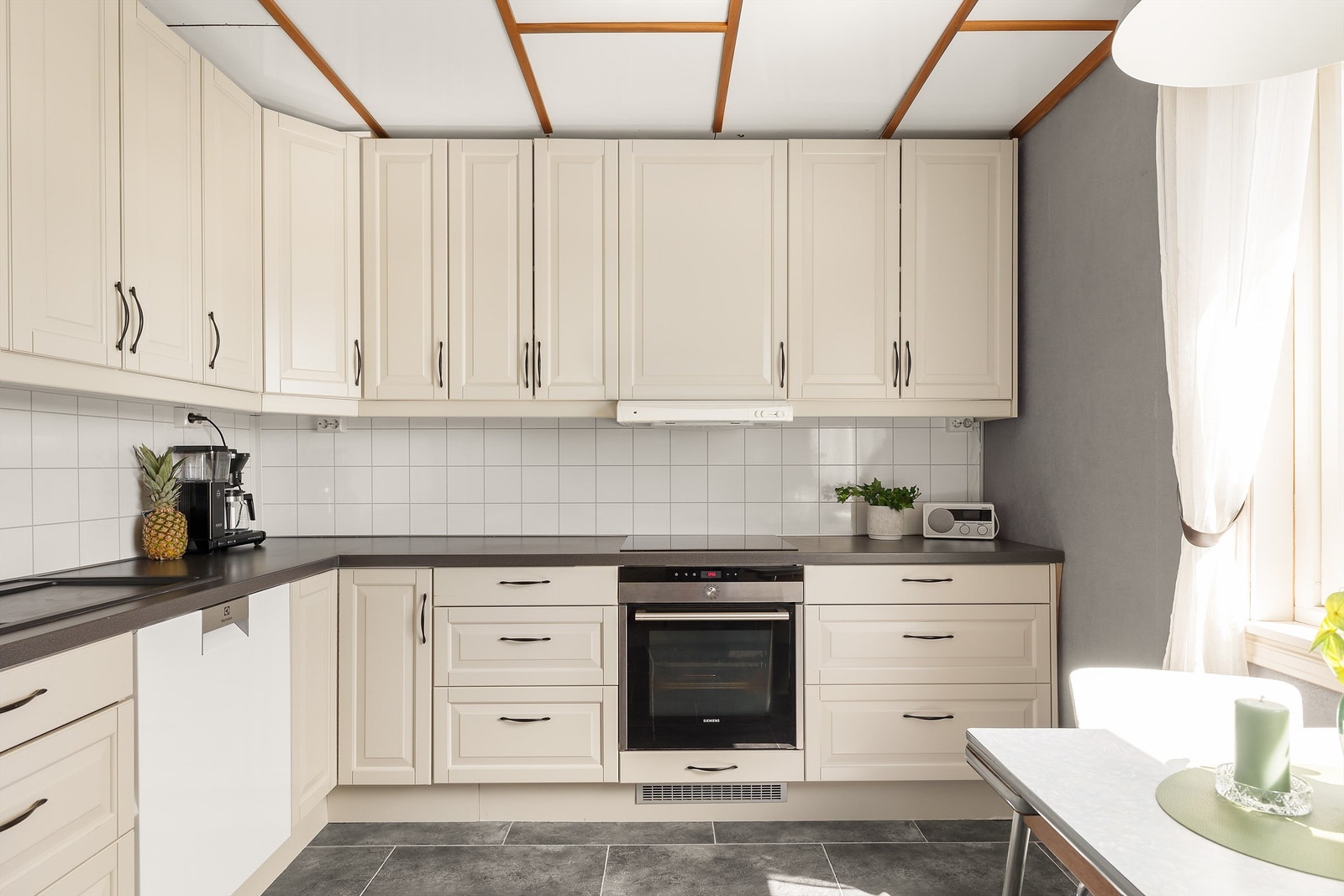 Kjøkkenet har godt med både skap og benkplass samt plass til koselig spisebord for de raskere måltidene Galleribilde