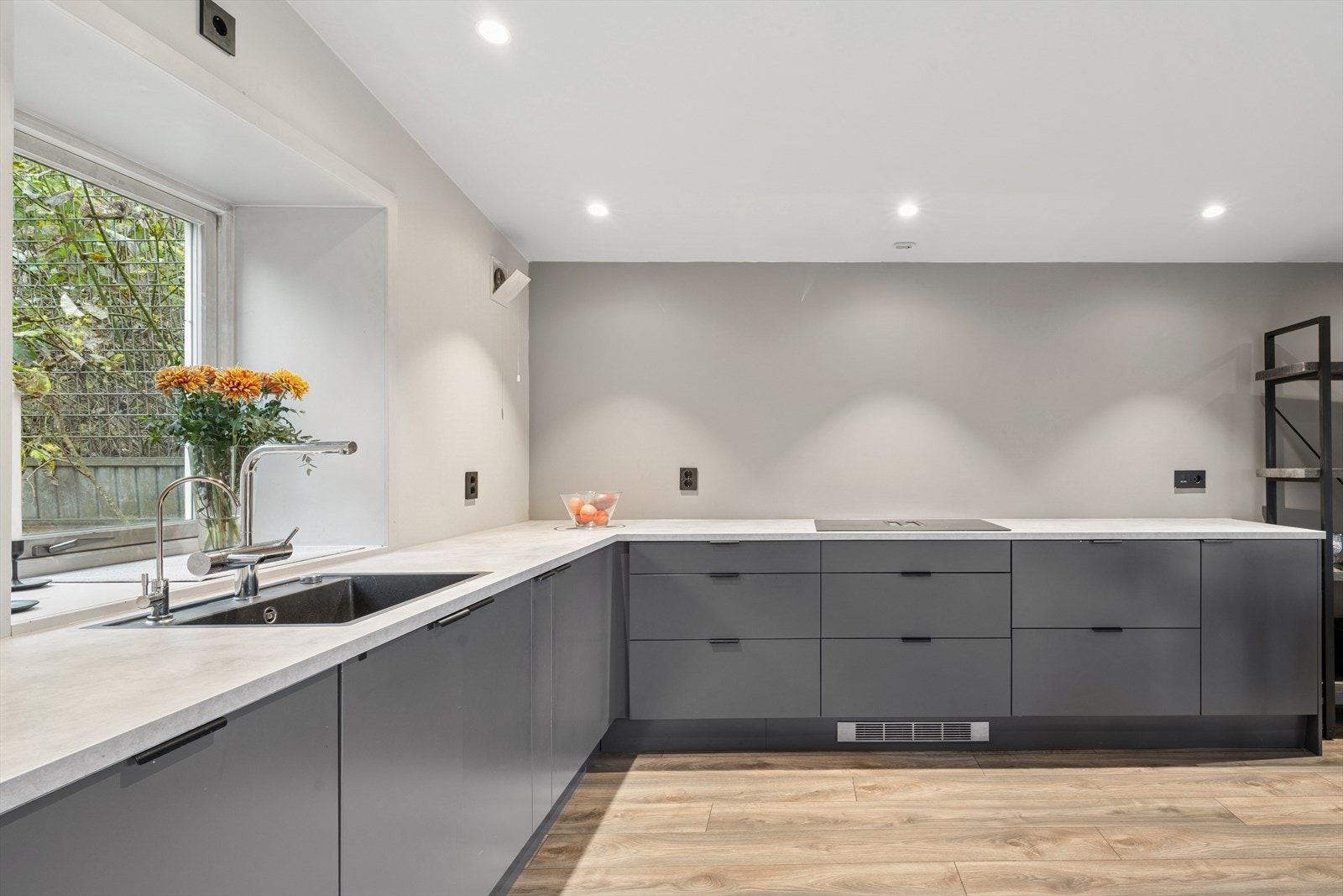 Moderne kjøkkeninnredning med slette fronter, integrert platetopp og rikelig med benkeplass. Galleribilde