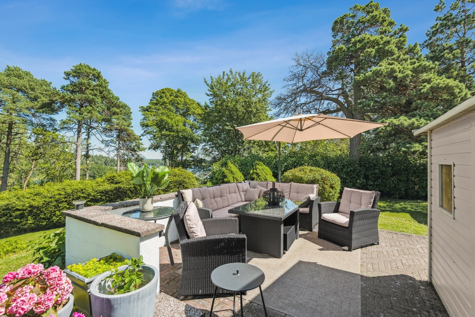 Uteplass med utsikt mot grøntområde og romslig plass til sittegruppe. Galleribilde