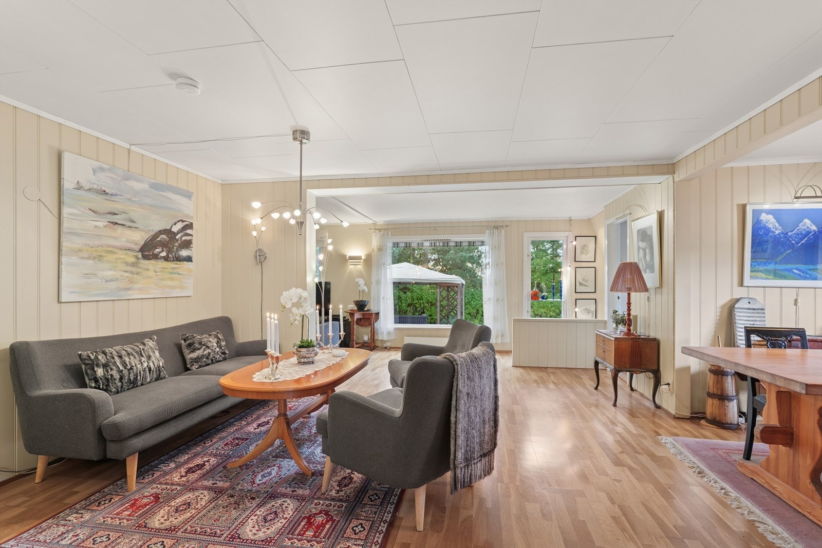 Store vindusflater gir flott naturlig lys inn. Parkettgulv strekker seg gjennom stueområdet og gir et enhetlig uttrykk. Galleribilde