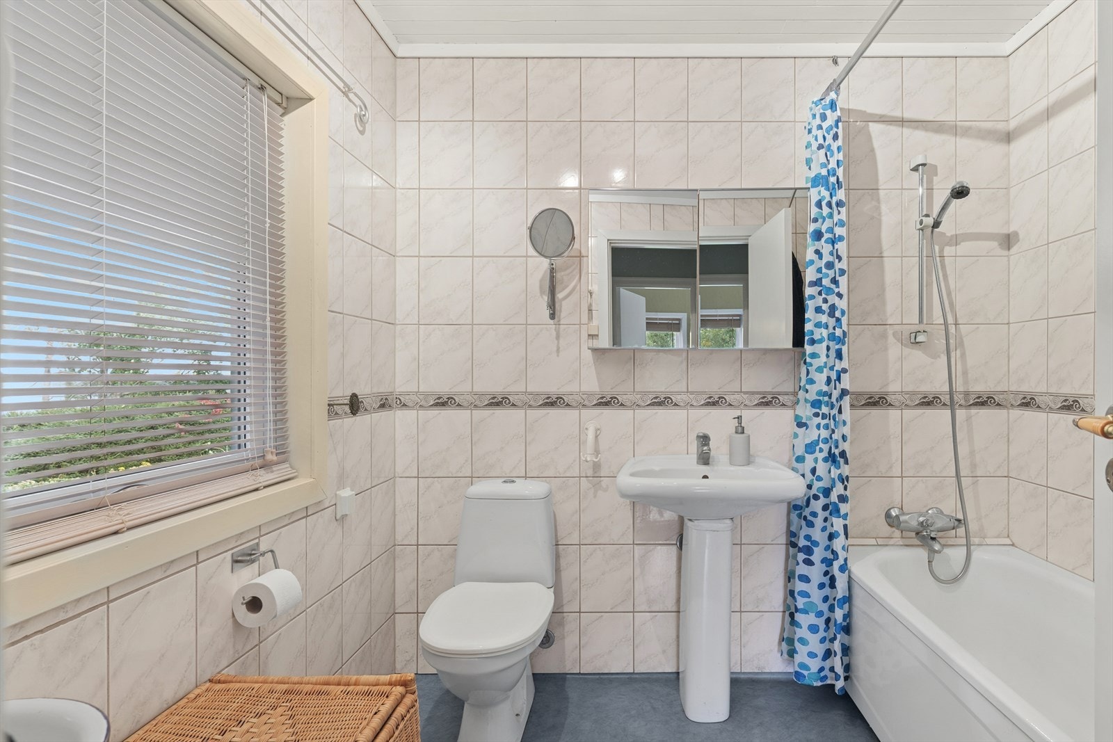 Baderom nr. 2 med fliser på veggene og belegg på gulvet. Innredet med badekar, vask og gulvmontert toalett. Galleribilde