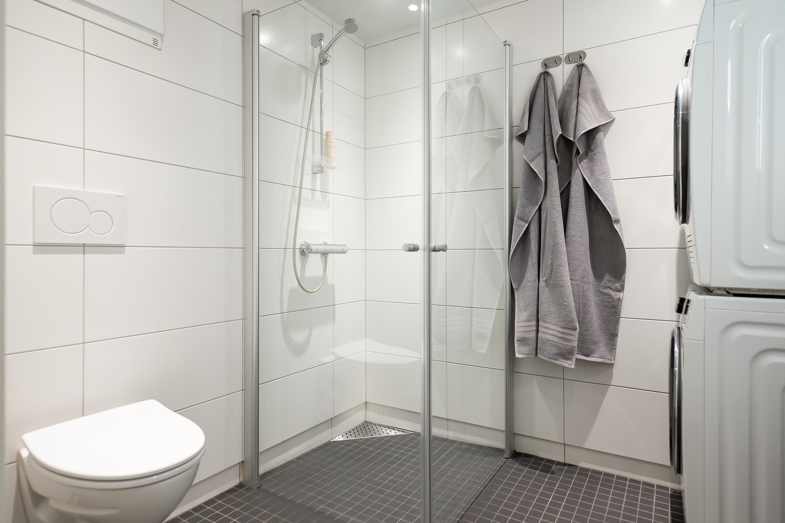 Badet har innredning med servant, speil, toalett, dusj og opplegg for vaskemaskin. Galleribilde