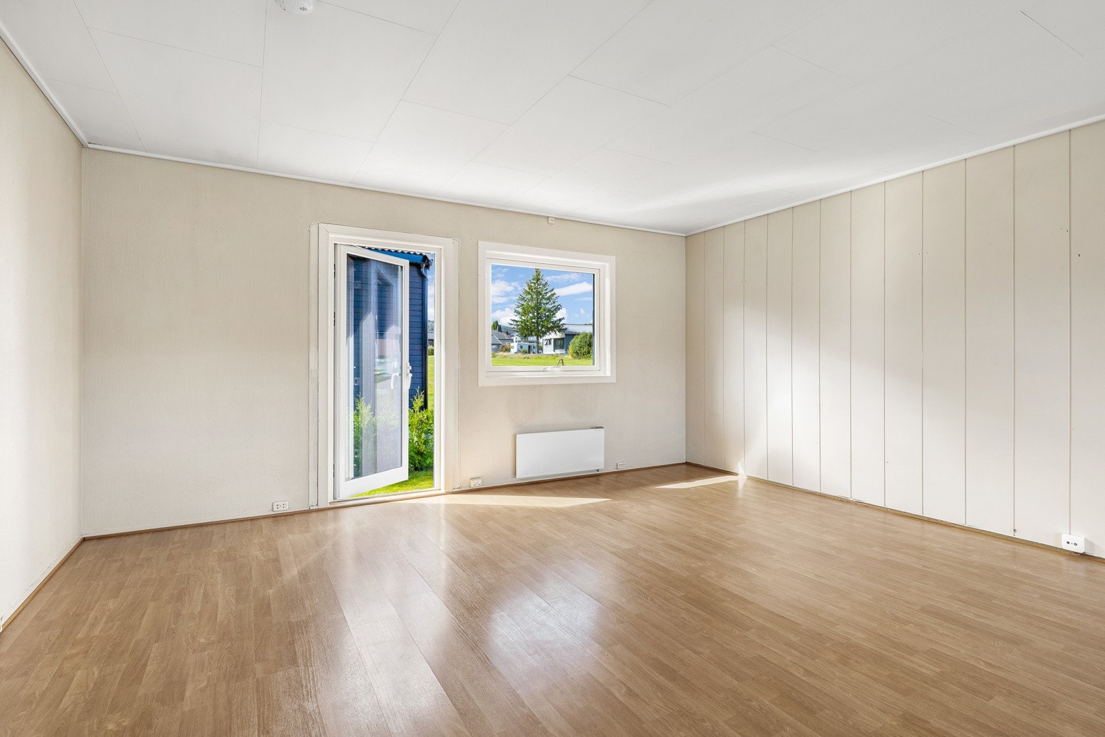 Romslig stue med store vinduer og god lysinnslipp, utgang til hagen gjennom balkongdør. Galleribilde