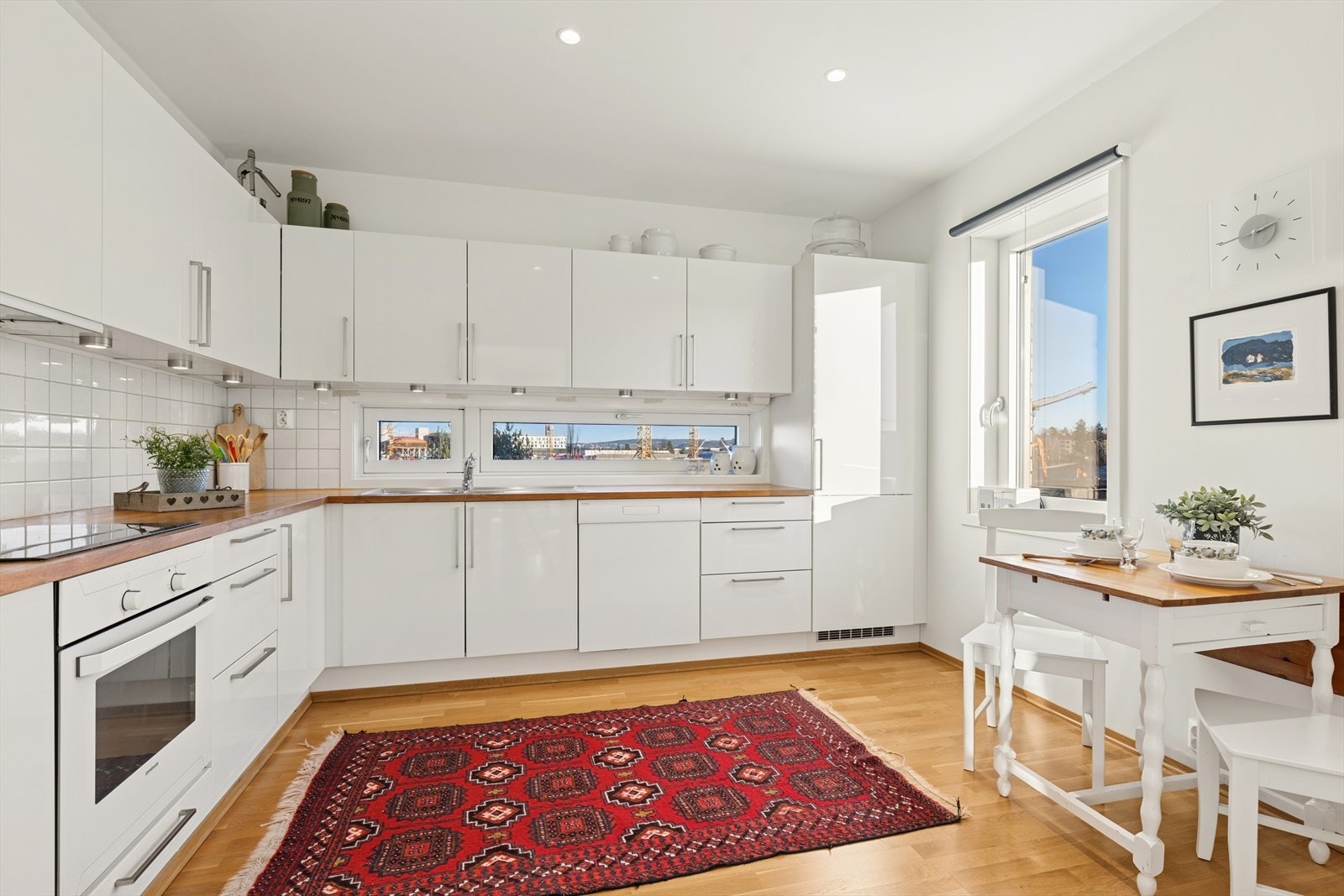 Et stilrent kjøkken med heltre benkeplate og integrerte hvitevarer - perfekt for både hverdagsmåltider og hyggelige middager. Galleribilde