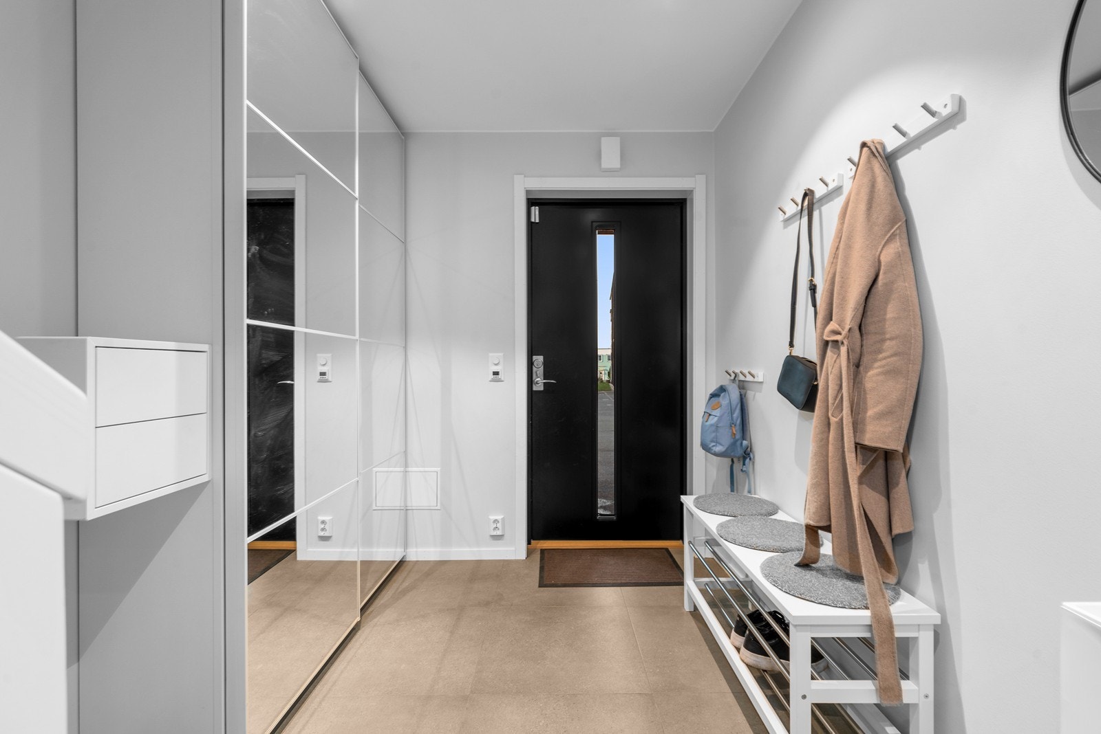 Entréen har sandfargede fliser med gulvvarme og god plass til garderobeløsning. Galleribilde