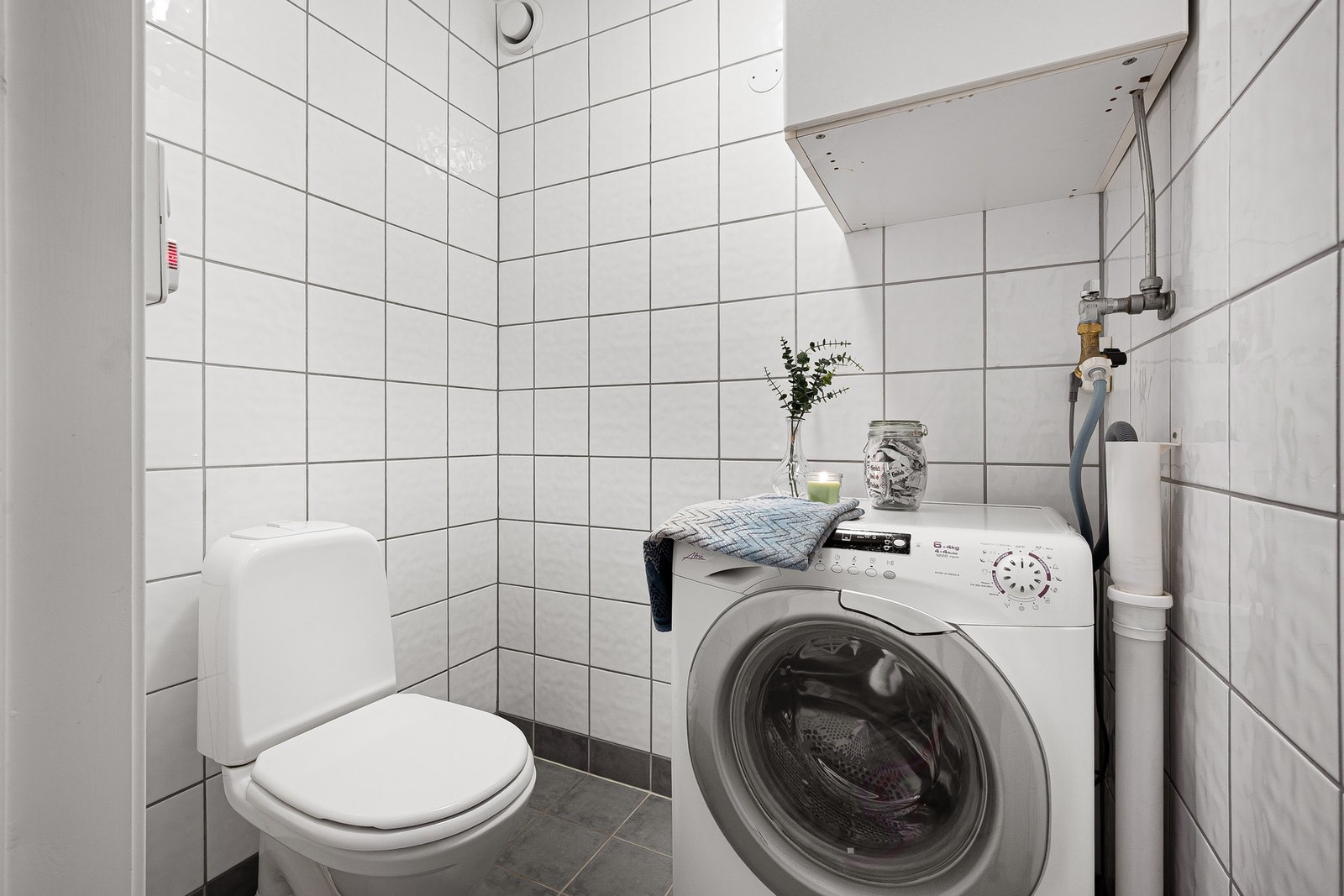 Leiligheten har eget praktisk toalettrom med opplegg for vaskemaskin. Galleribilde