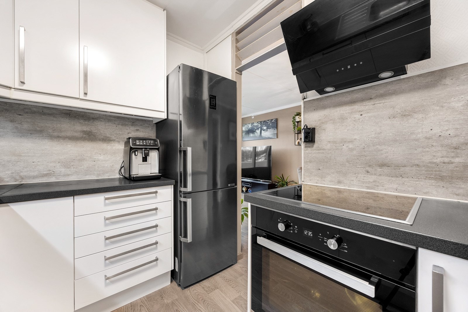 Kjøkkenet er godt utnyttet, med benkeplater og skap som strekker seg helt opp til taket og gir maksimal oppbevaringsplass. Galleribilde