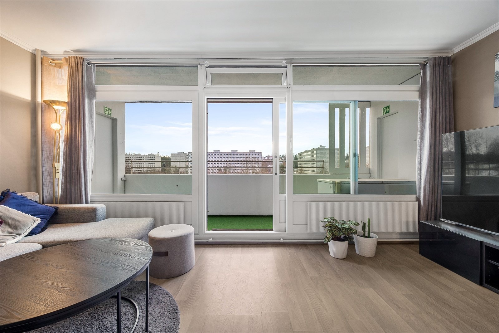 En praktisk skyvedør gir enkel adkomst til balkongen og gjør uteplassen til en naturlig forlengelse av stuen. Galleribilde