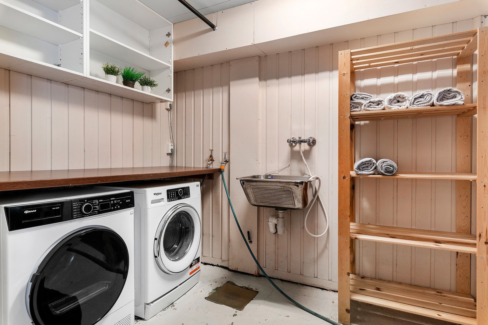 Vaskerommet har skyllekar, opplegg for vaskemaksin og tørketrommel og en laminert benkeplate. Galleribilde