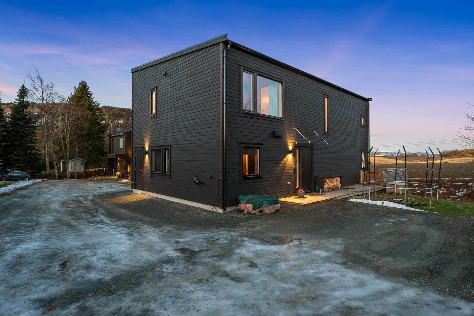 Det er gode parkeringsmuligheter på gruslagt gårdsplass hvor det også er opplegg for elbillader. Galleribilde